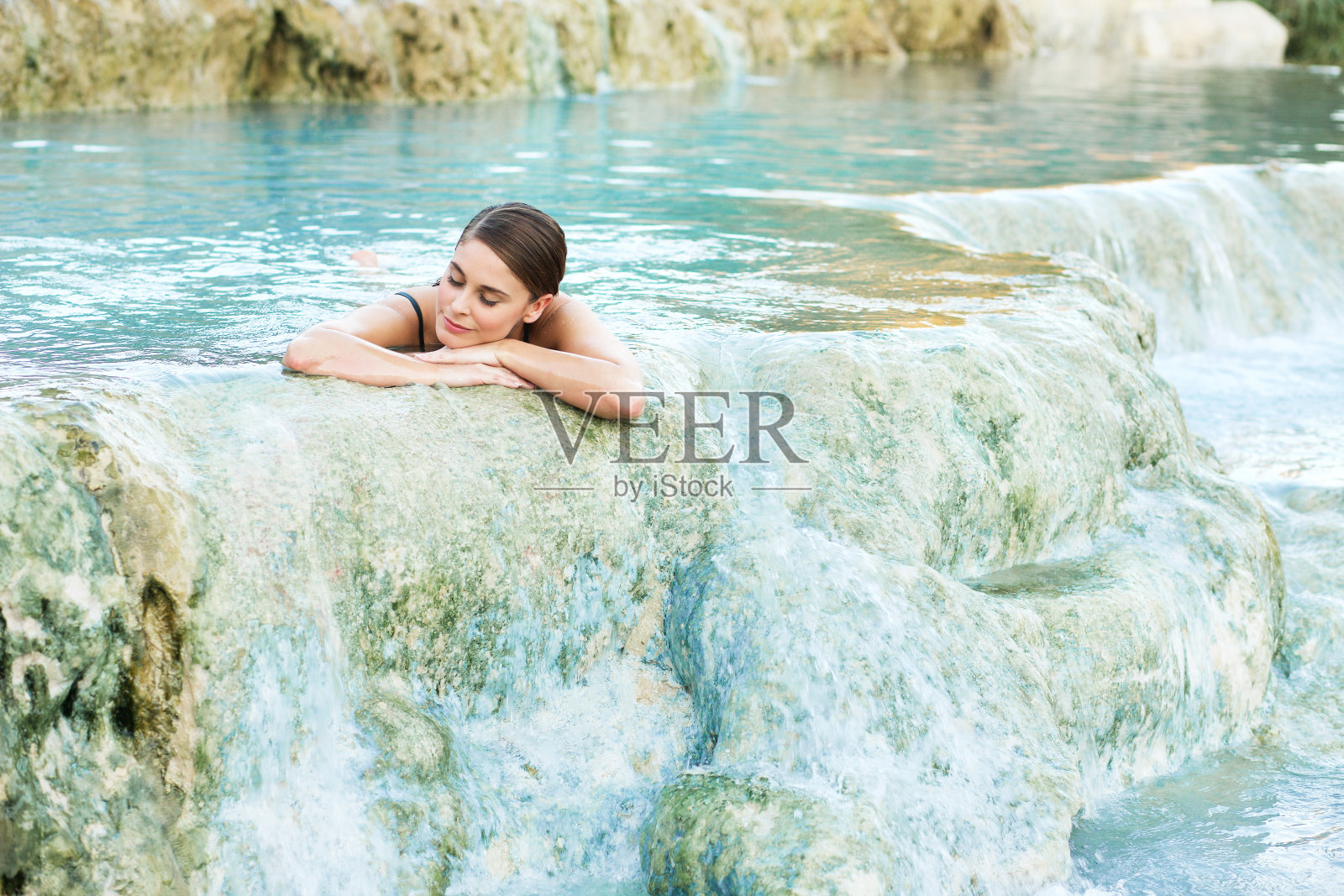一名女子躺在意大利萨图尼亚美丽的天然泳池里照片摄影图片