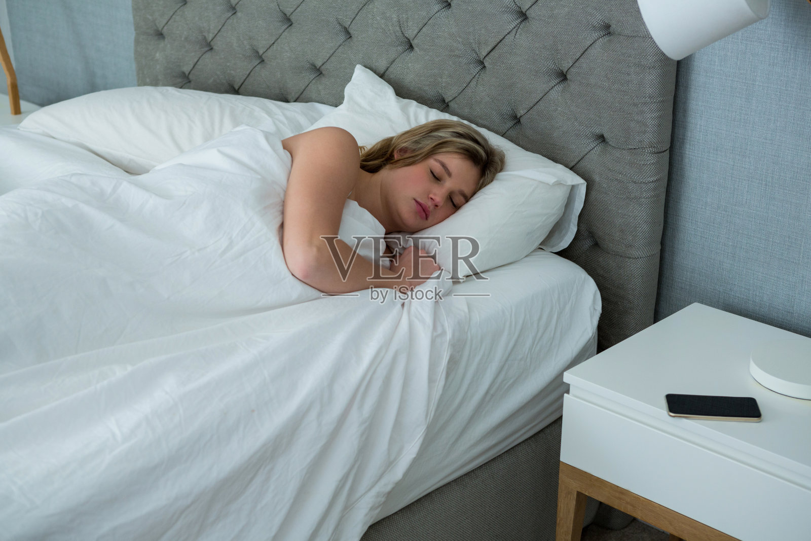 年轻女子睡在自己的床上照片摄影图片