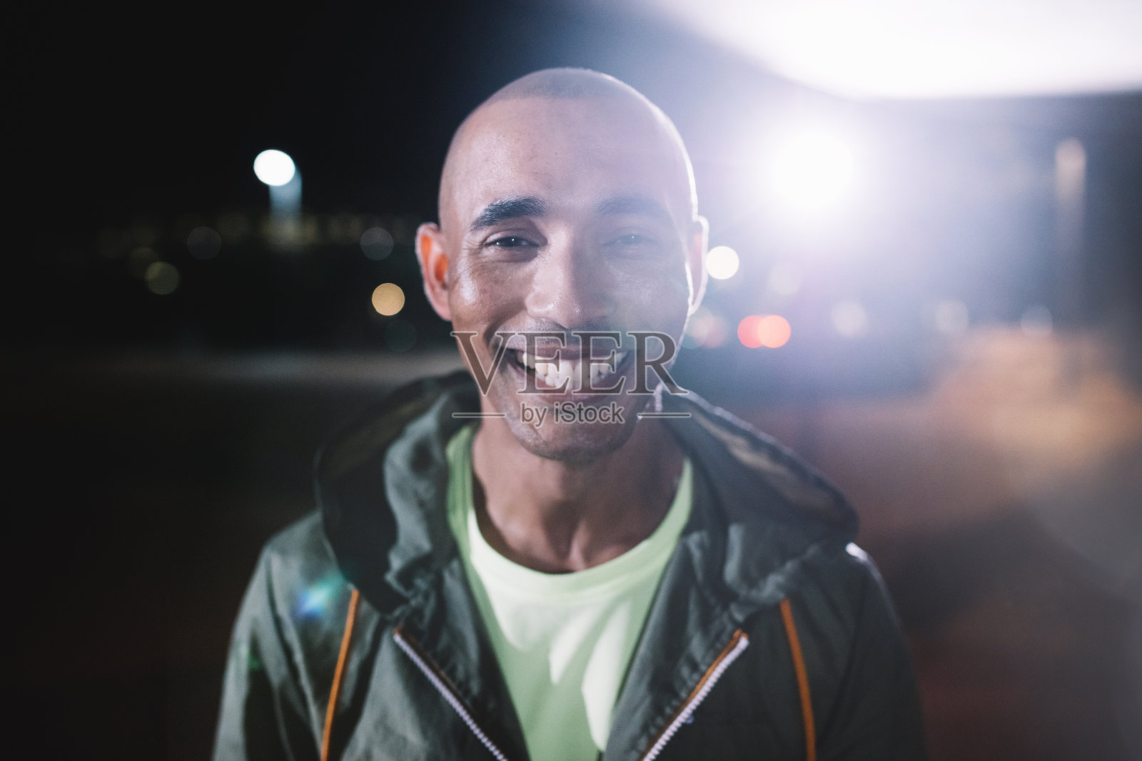 微笑的跑步者站在夜晚的城市里照片摄影图片