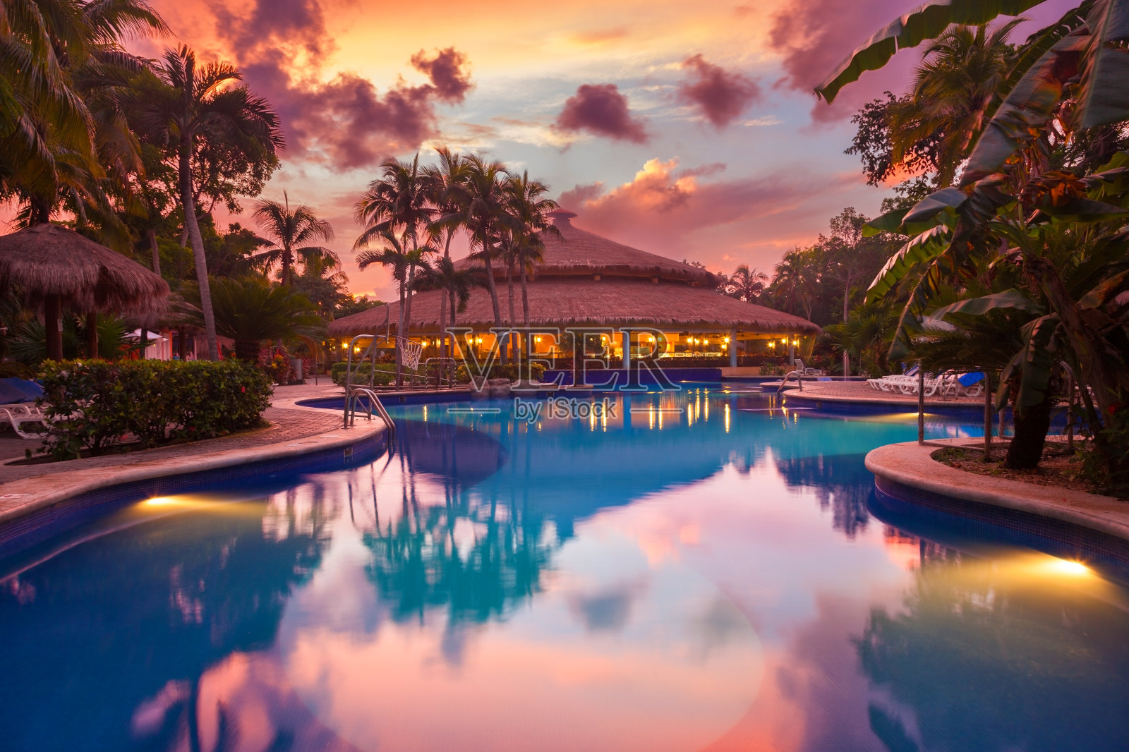 日落时分热带度假胜地的豪华游泳池照片摄影图片