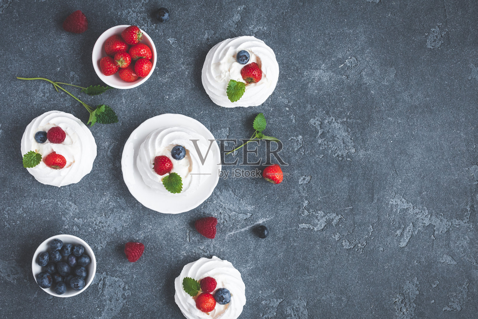 蛋白酥皮巴芙洛娃蛋糕，以草莓和蓝莓为背景照片摄影图片