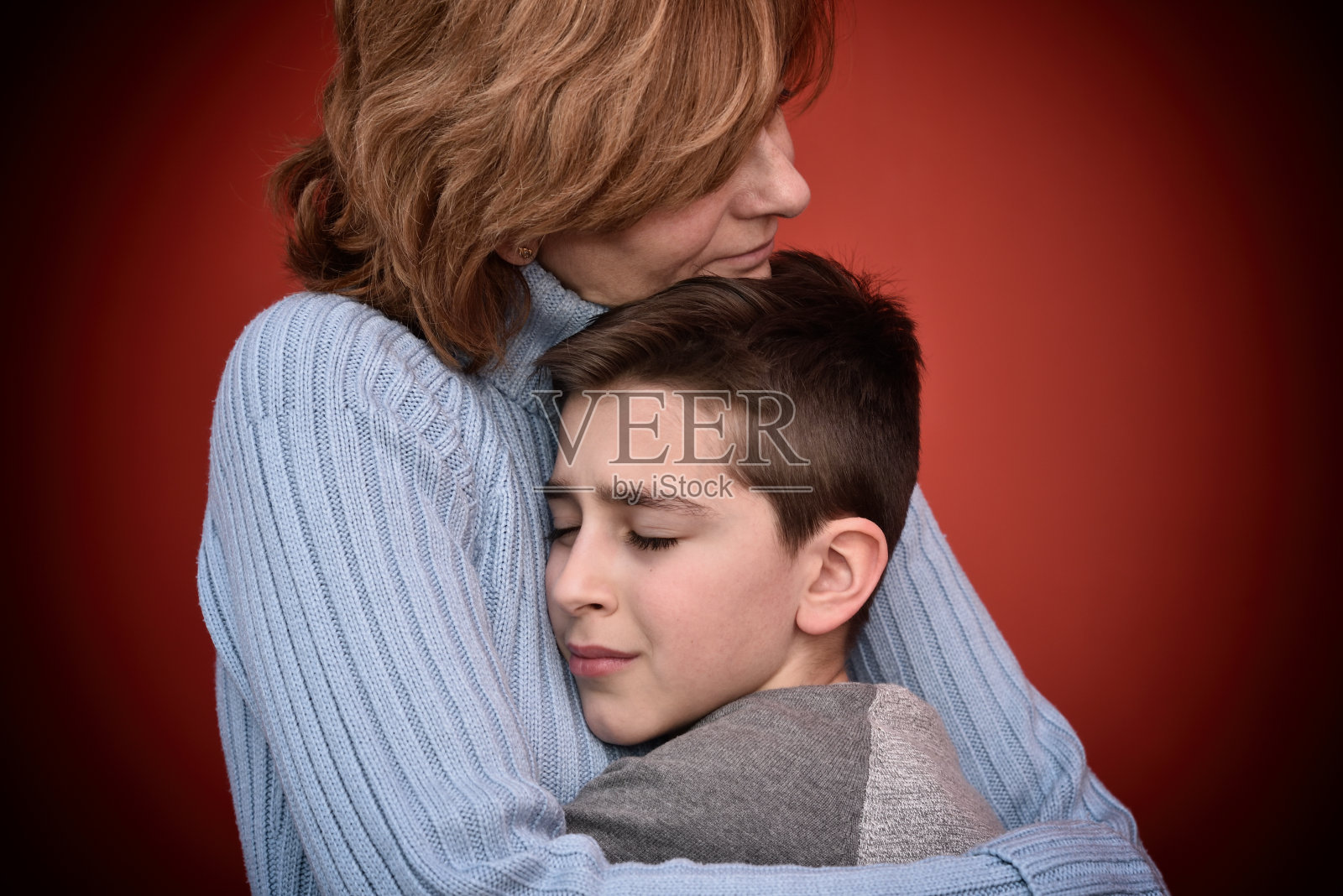 小男孩拥抱着他的母亲照片摄影图片