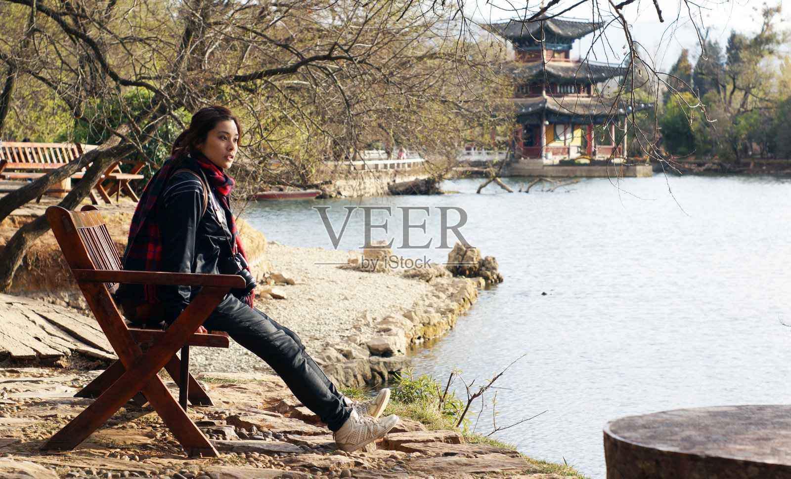 女孩坐在传统的中国公园景观后面照片摄影图片