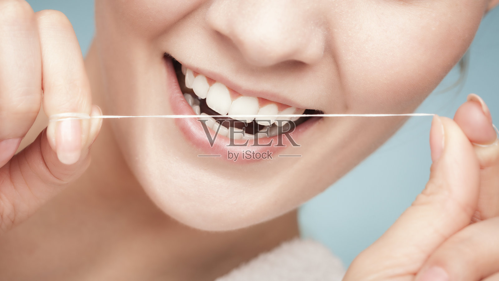 女孩用牙线清洁牙齿。卫生保健照片摄影图片