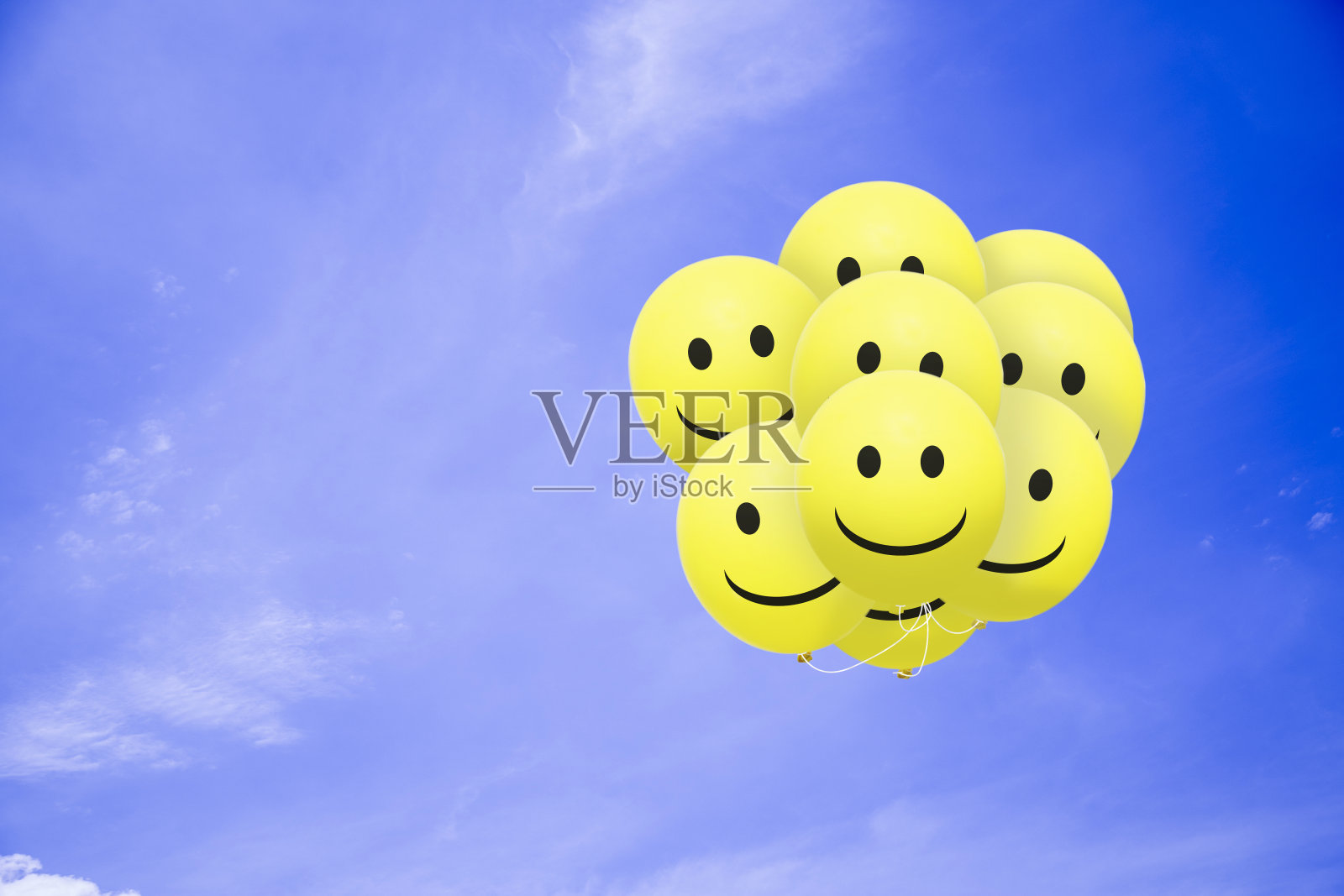灿烂微笑的气球在蓝天上飞翔照片摄影图片