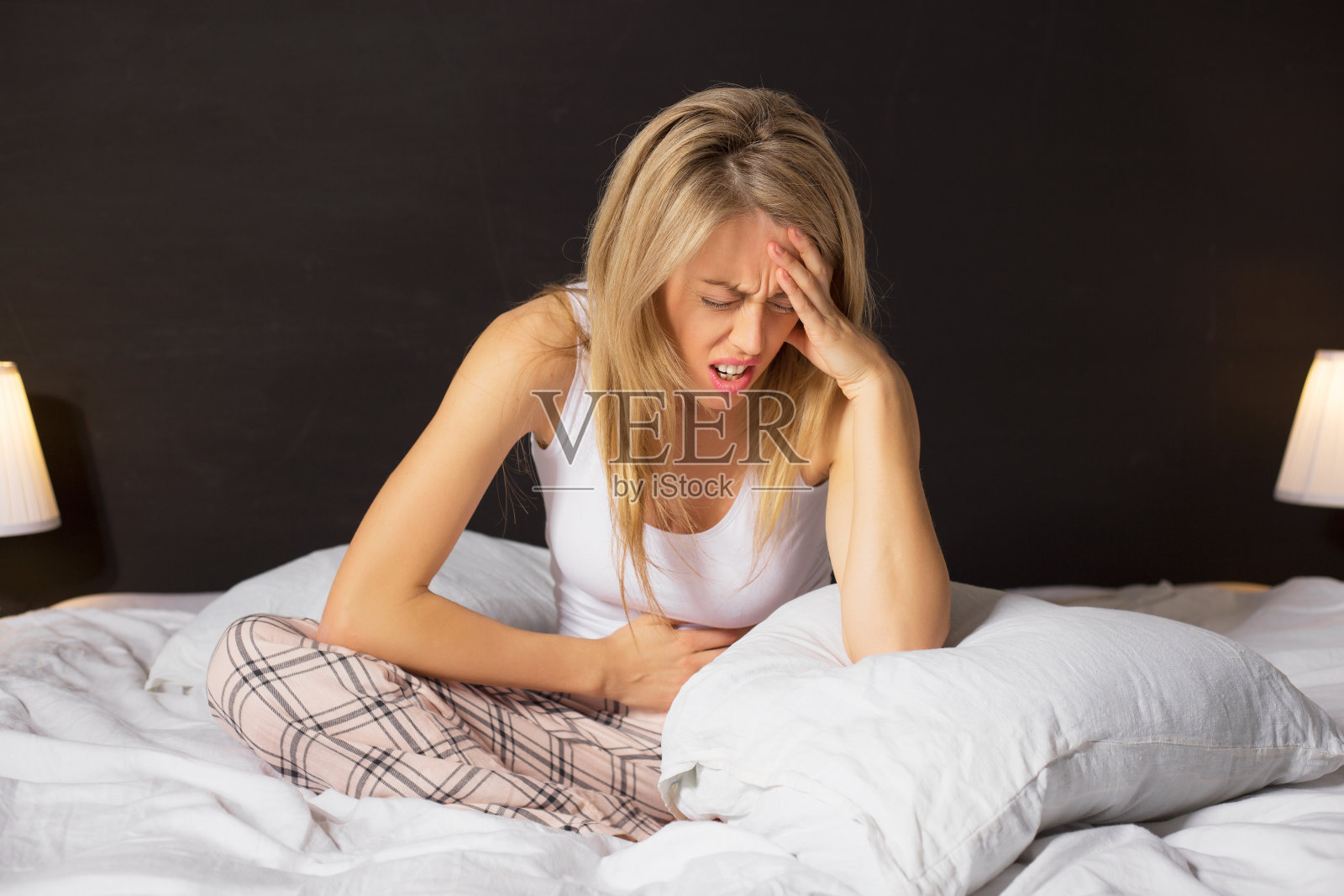 坐在床上痛苦的女人照片摄影图片