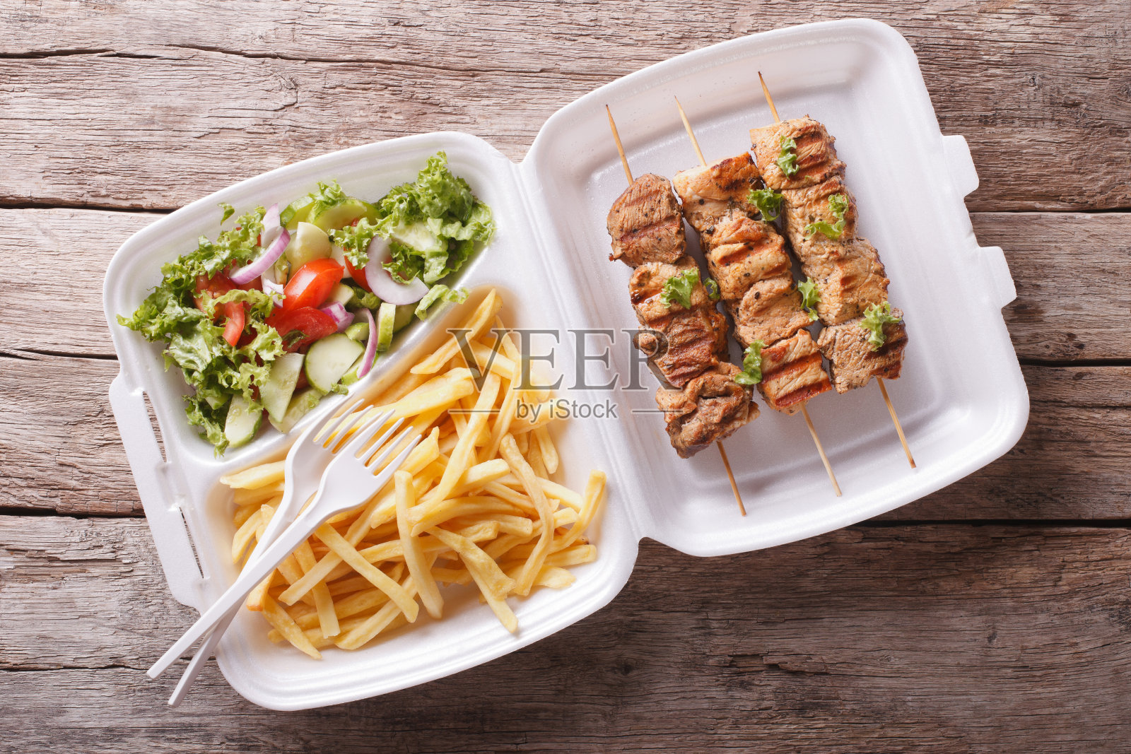 快餐:烤肉串、薯条和新鲜沙拉。水平照片摄影图片