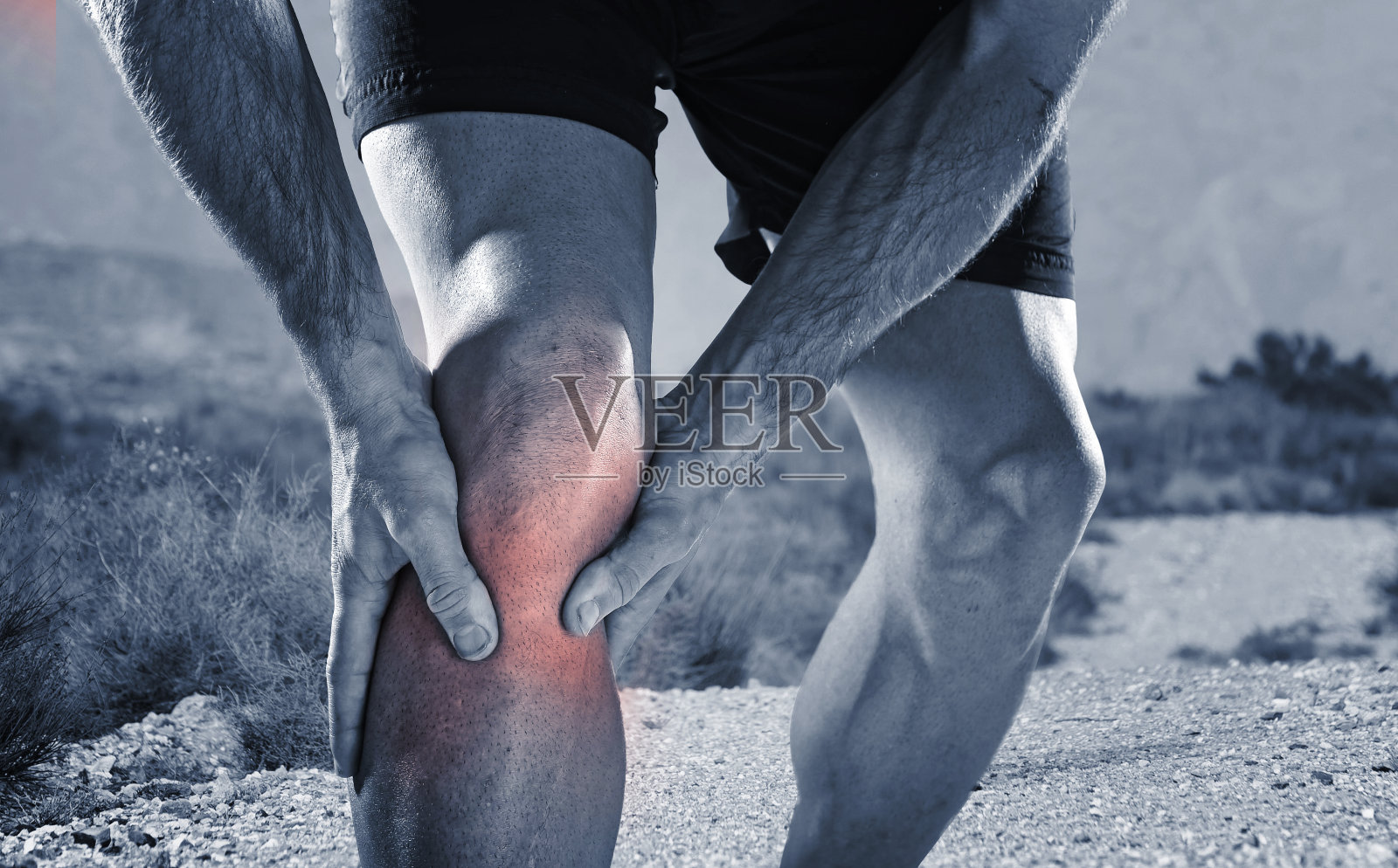 跑步男子抱着膝盖在疼痛中遭受肌肉抽筋损伤照片摄影图片