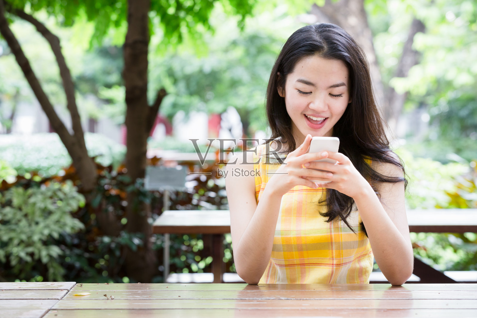 年轻的亚洲女子愉快地使用智能手机照片摄影图片