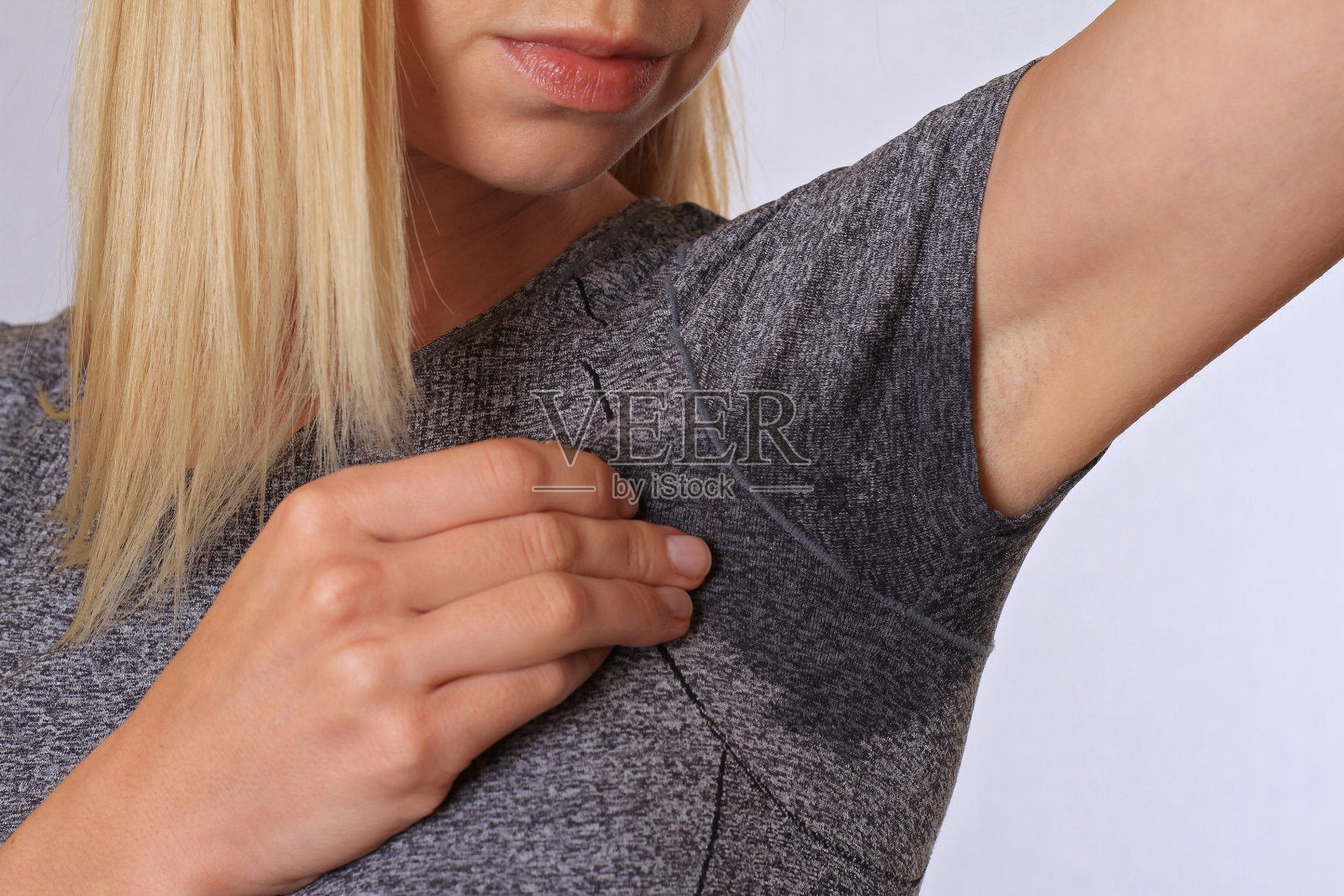 运动女性腋下出汗。蒸腾污渍。甲状腺机能亢进的概念照片摄影图片