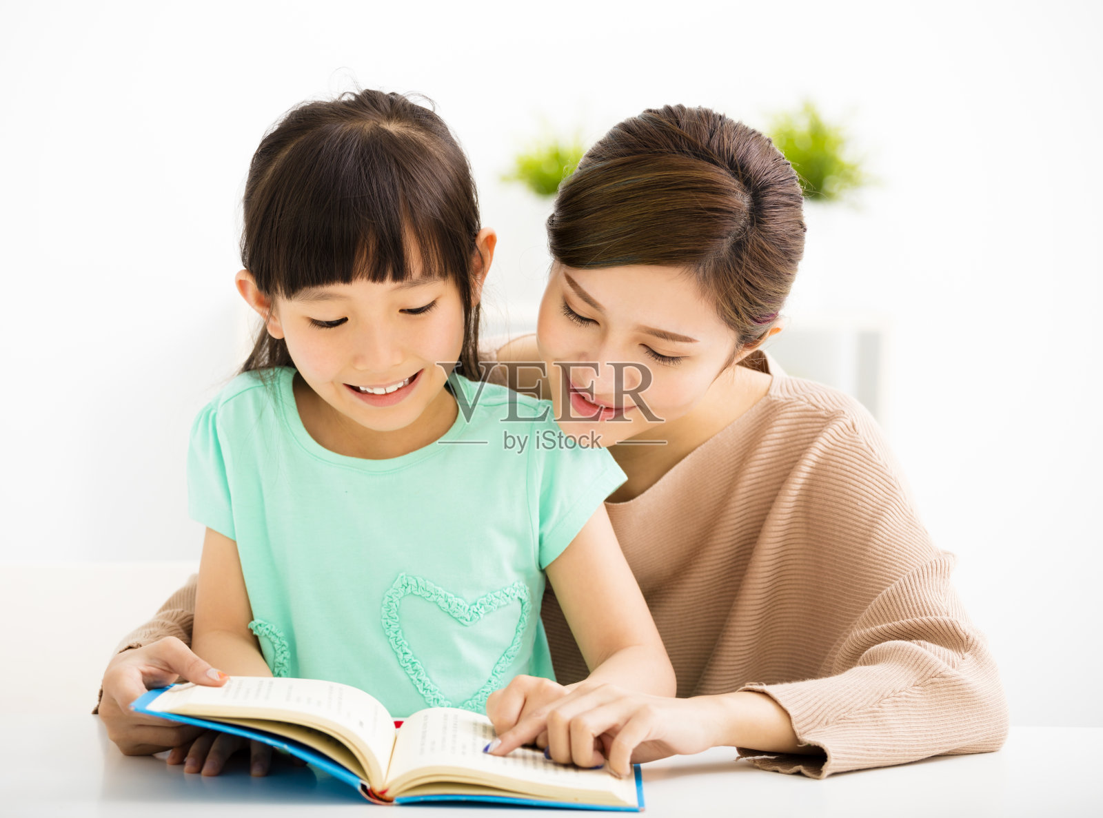 小女孩和她的妈妈一起看书照片摄影图片