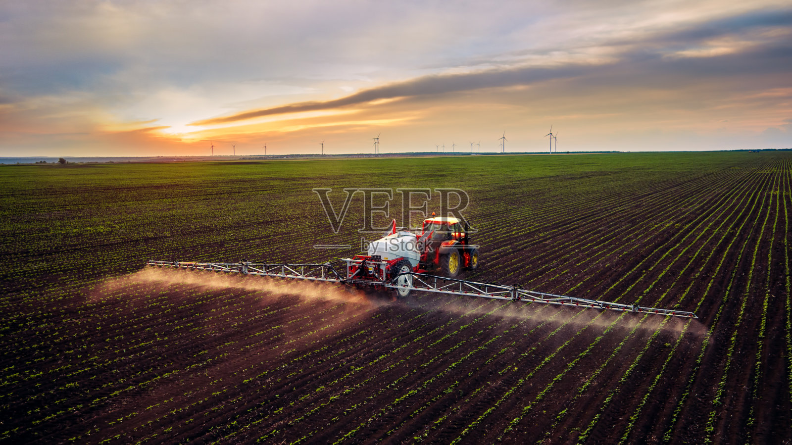 拖拉机在春天喷洒农田照片摄影图片