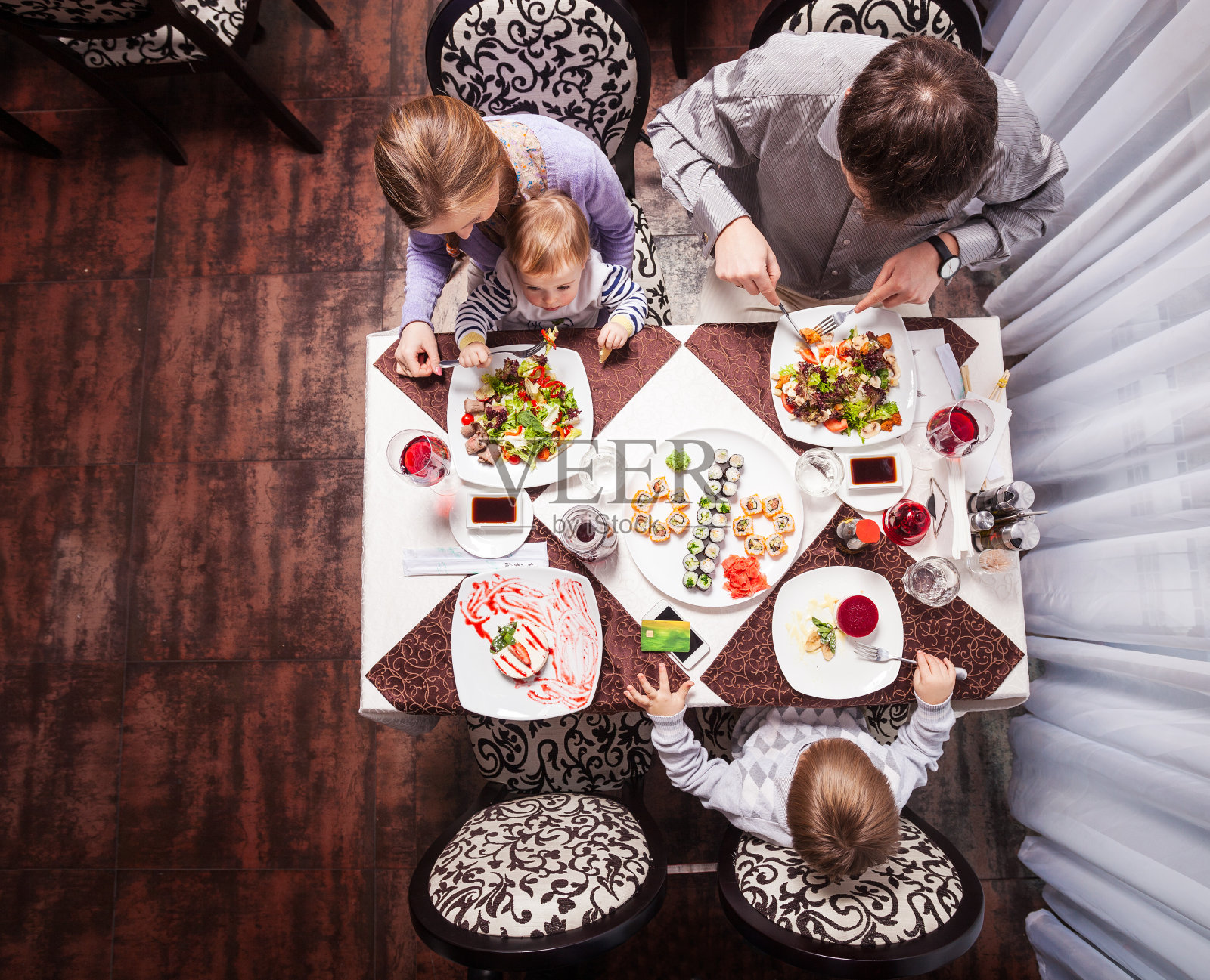 一家四口在餐馆吃饭照片摄影图片