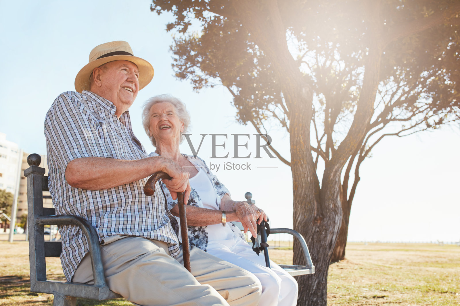 一对轻松的老夫妇坐在公园的长椅上照片摄影图片