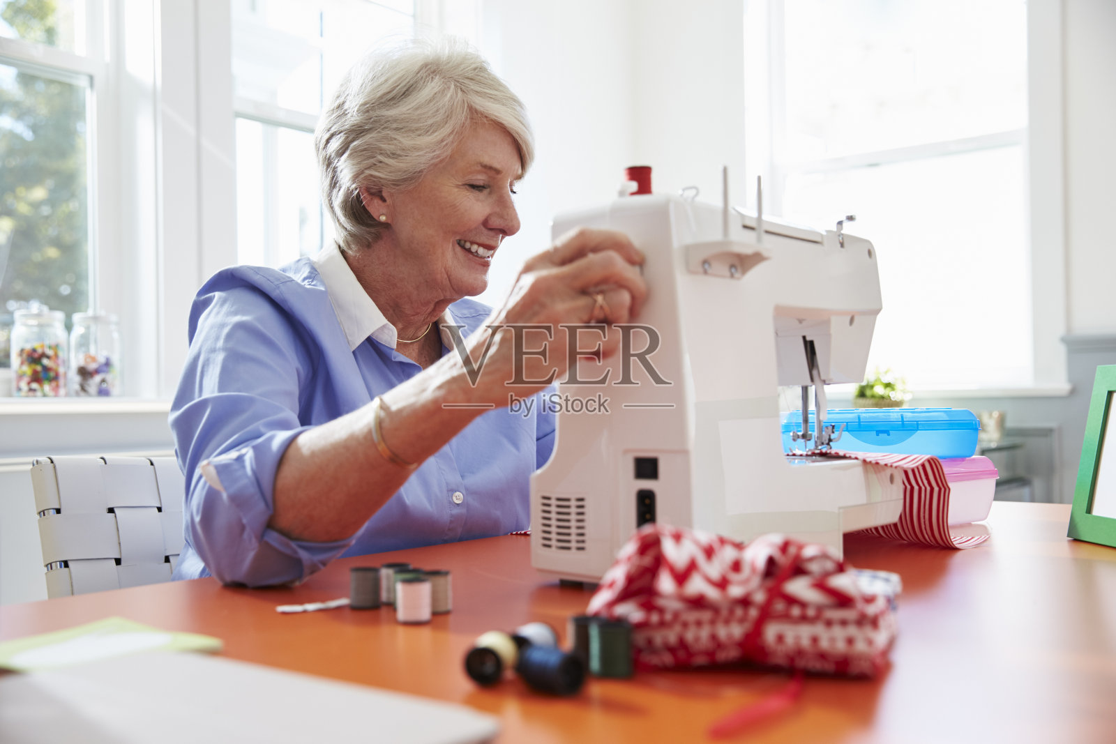 老年妇女在家用缝纫机做衣服照片摄影图片
