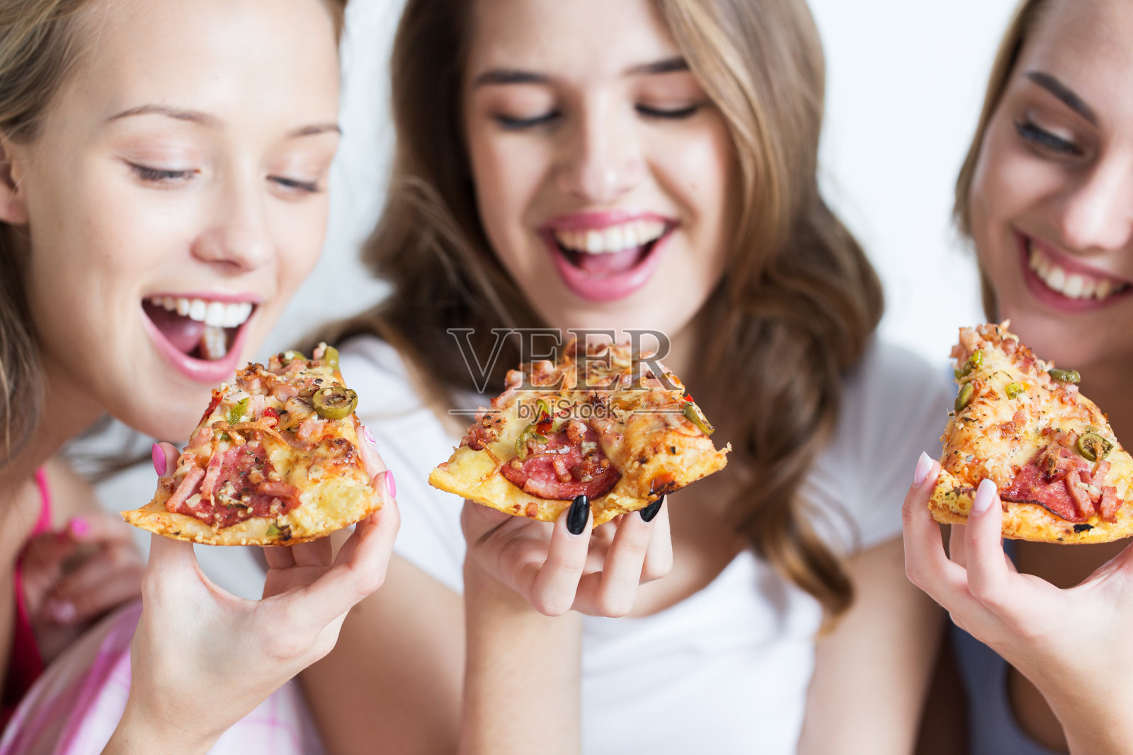 快乐的朋友或者年轻女孩在家吃披萨照片摄影图片