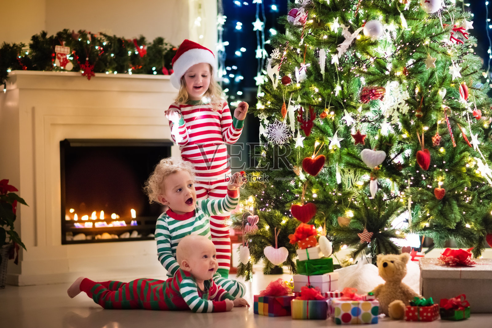 圣诞树下快乐的孩子们穿着睡衣照片摄影图片