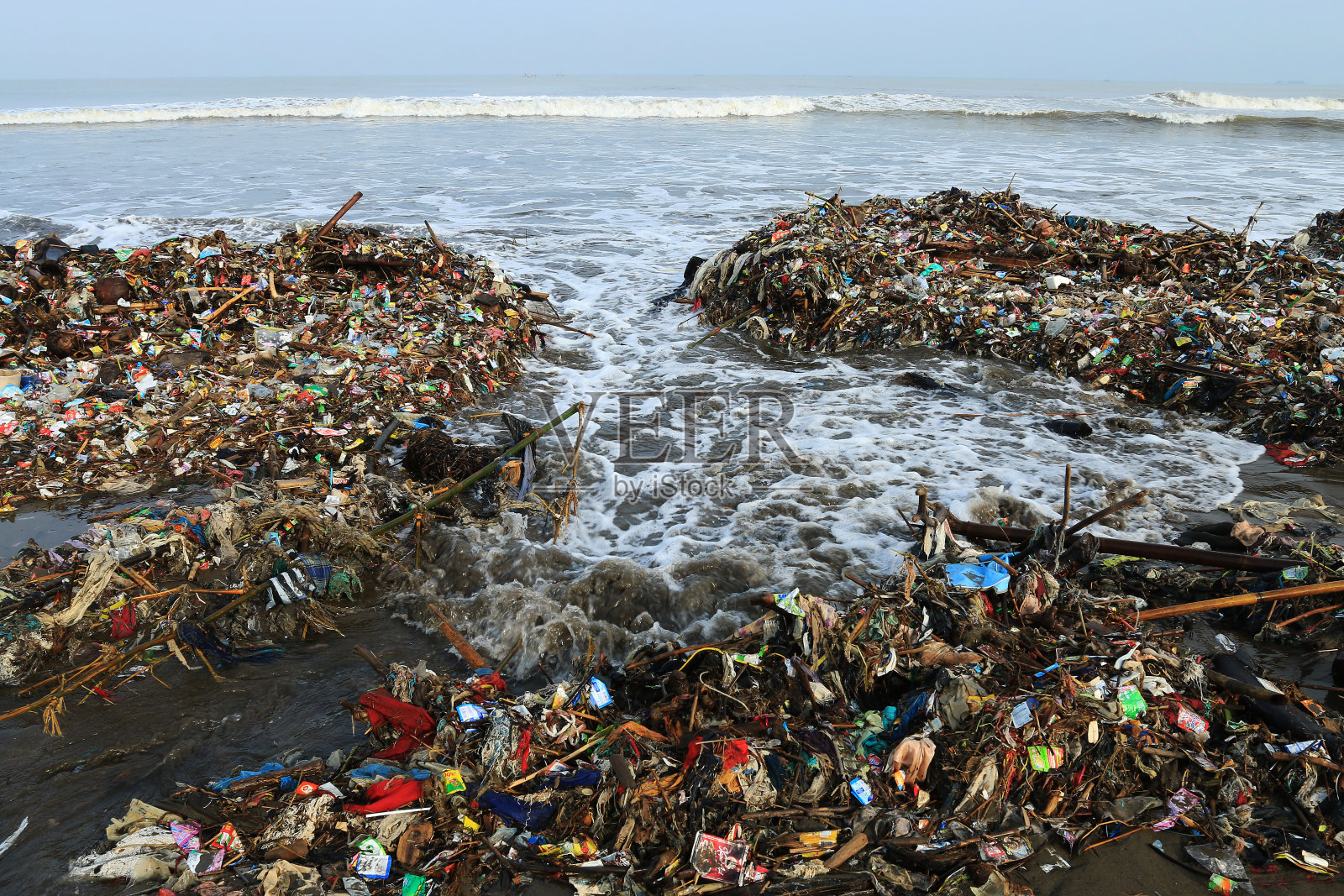 海滩上堆满了垃圾。照片摄影图片
