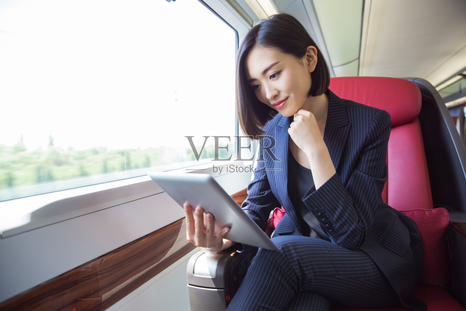 中国上海，美丽的女商人坐在高铁里。照片摄影图片