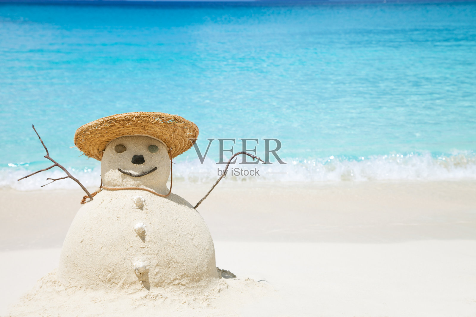 沙滩上用沙子做的雪人戴着草帽照片摄影图片