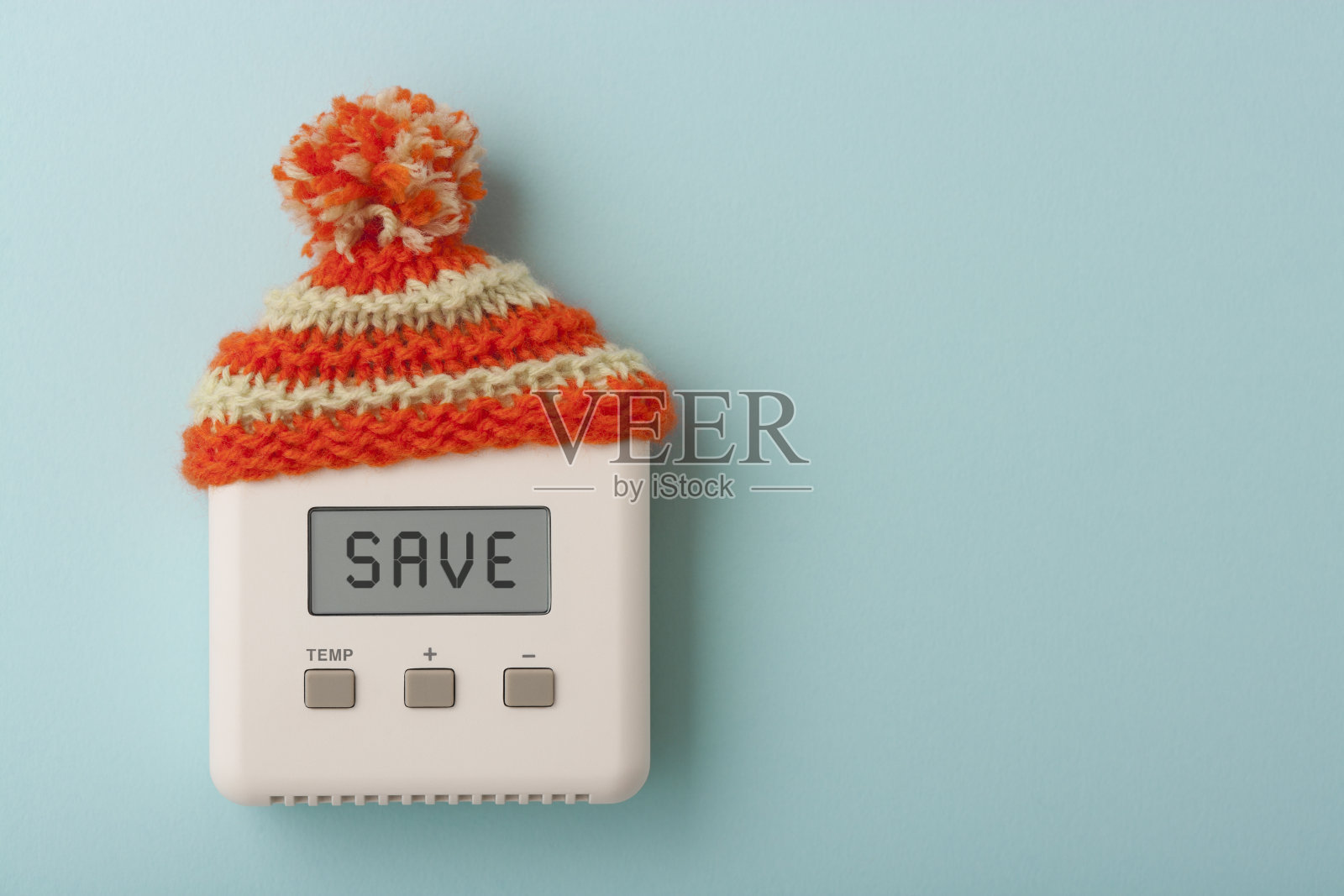 用羊毛帽子节省房间的数字恒温器照片摄影图片