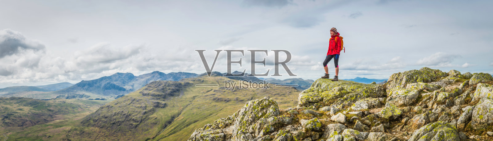 十几岁的女性徒步旅行者在岩石山顶俯瞰山顶全景照片摄影图片