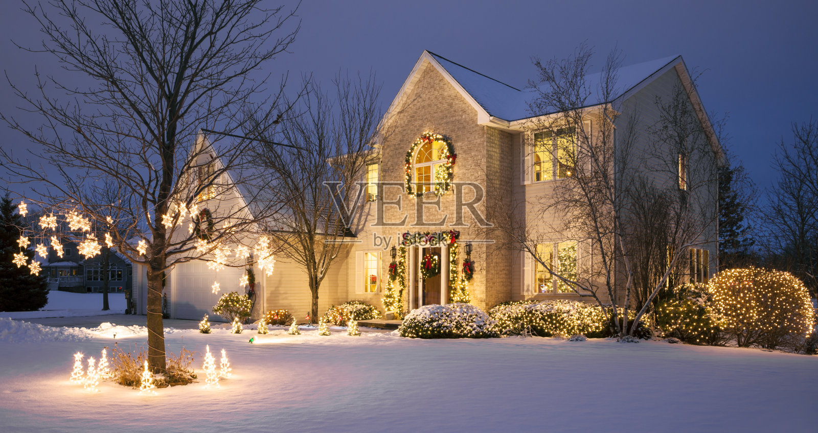 圣诞节的家与节日的灯光和雪照片摄影图片
