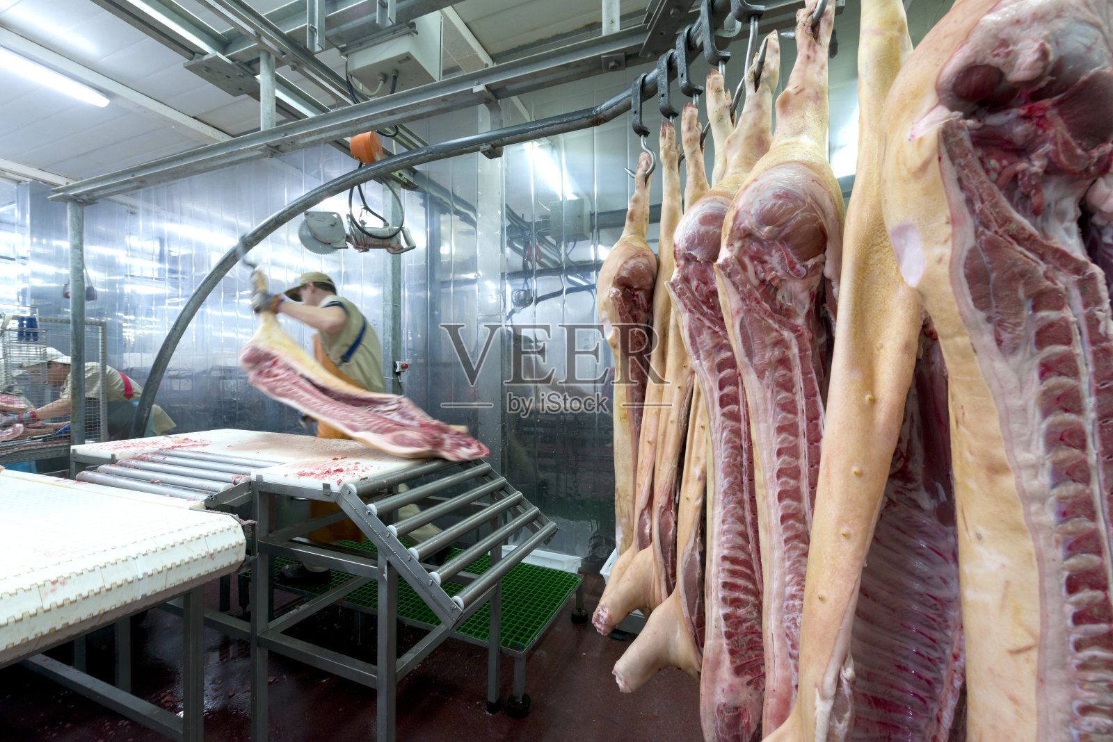 在食品加工厂切肉的屠夫照片摄影图片