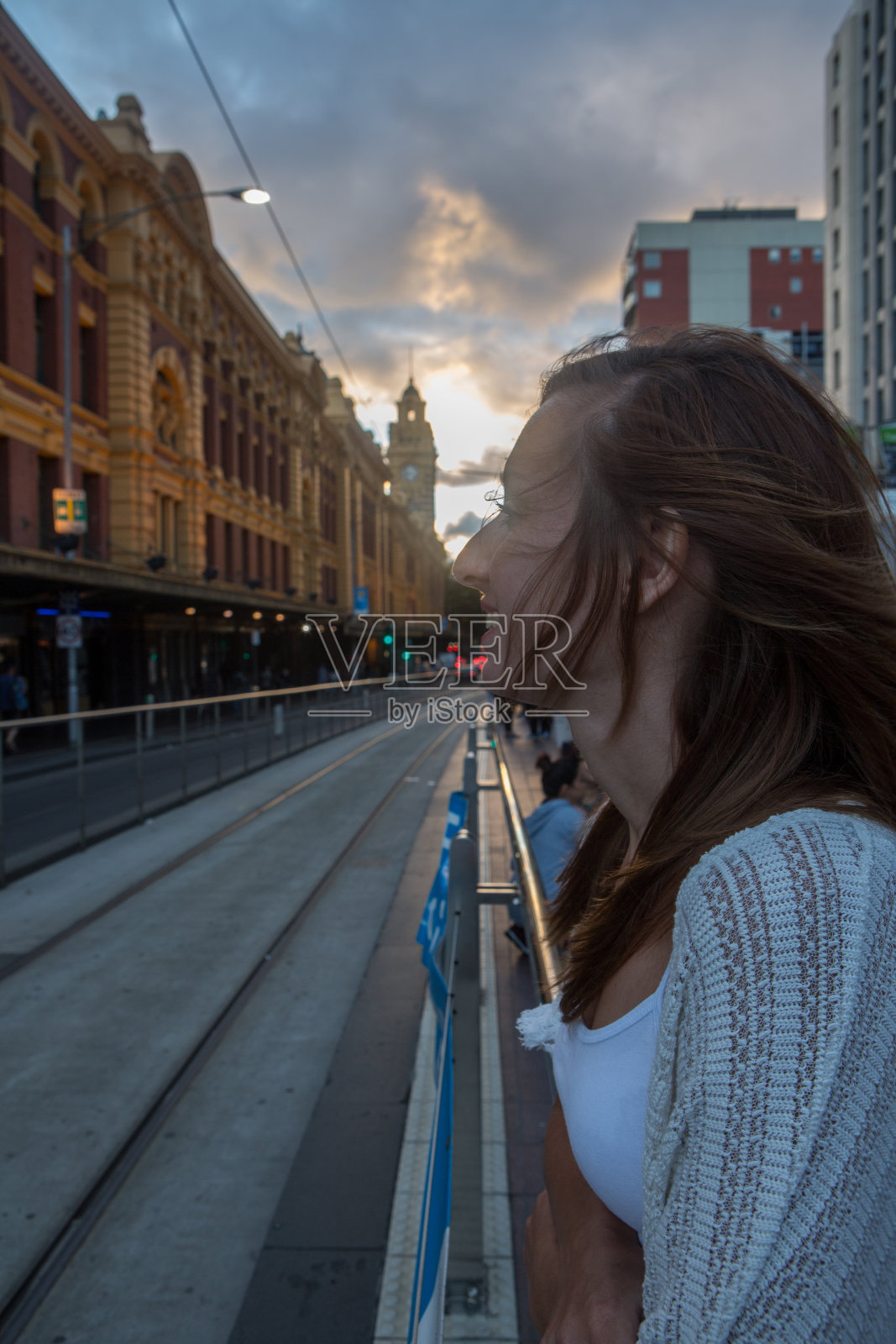 年轻女子在弗林德斯街火车站等电车照片摄影图片