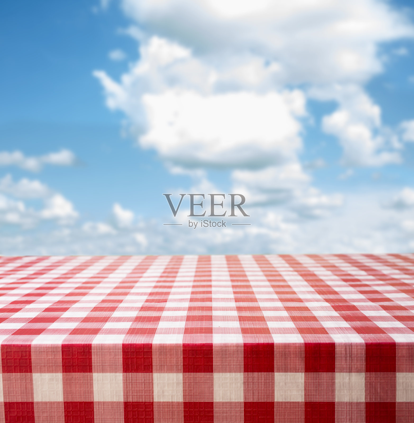 野餐时间!红色格子桌布，夏日多云的蓝天。照片摄影图片