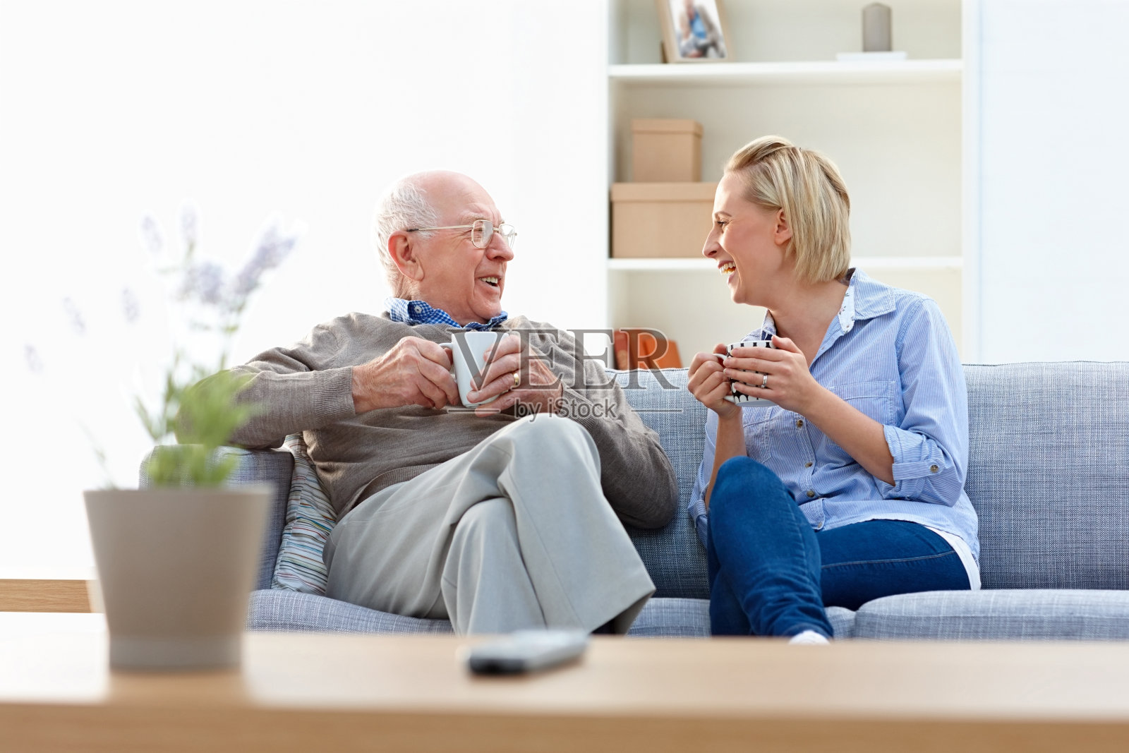 老年男女护理人员在客厅享受咖啡照片摄影图片