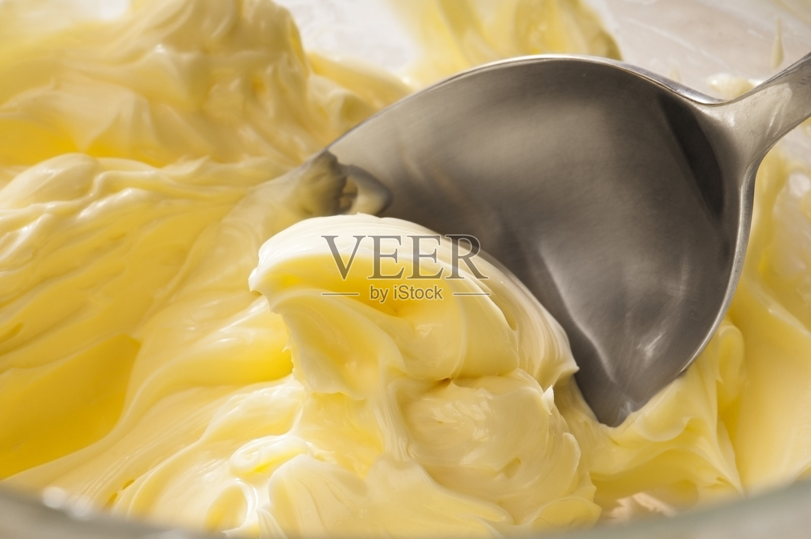 黄油、奶油、糖霜用勺子混合在一起照片摄影图片