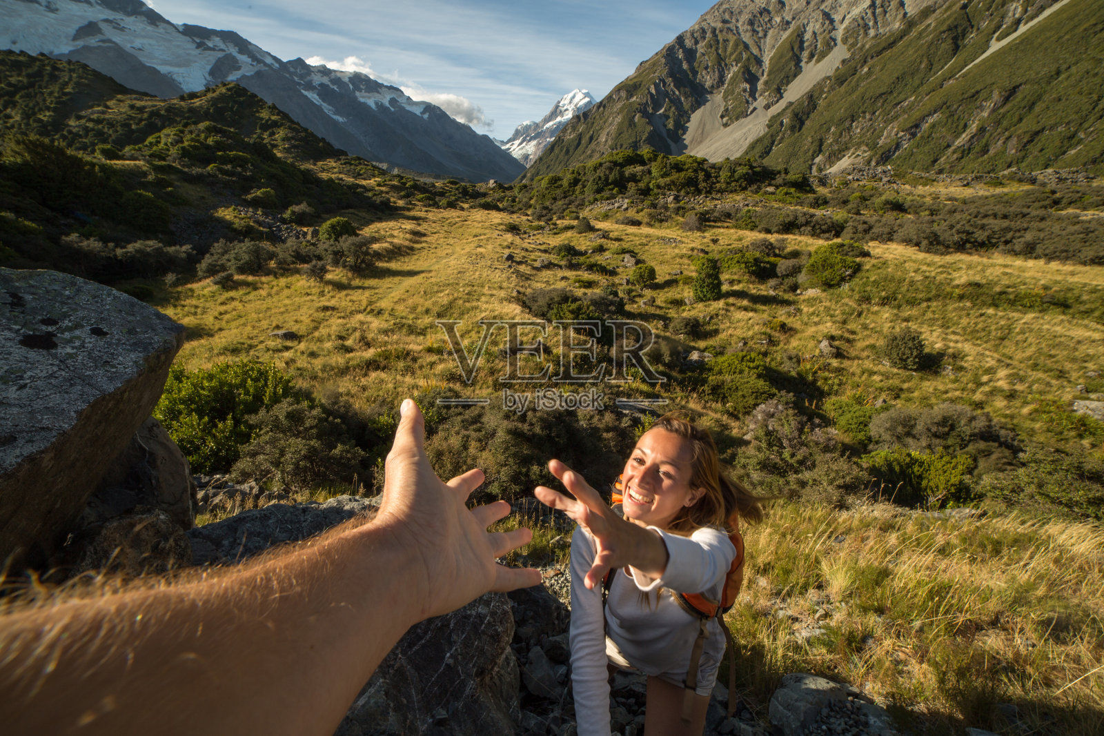 女登山队员伸出手向队友求助照片摄影图片