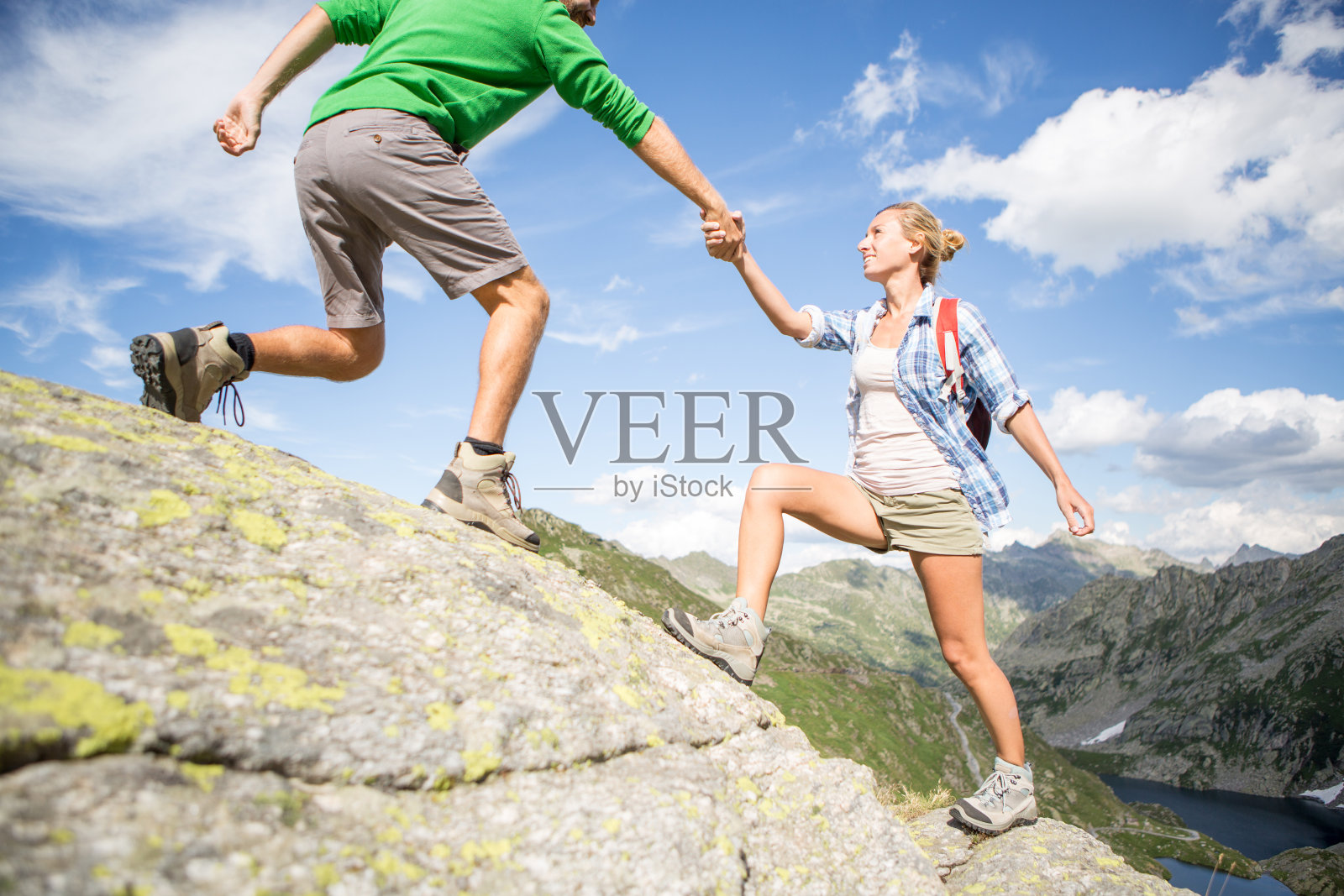 登山者帮助另一个人攀上山顶——夏天照片摄影图片