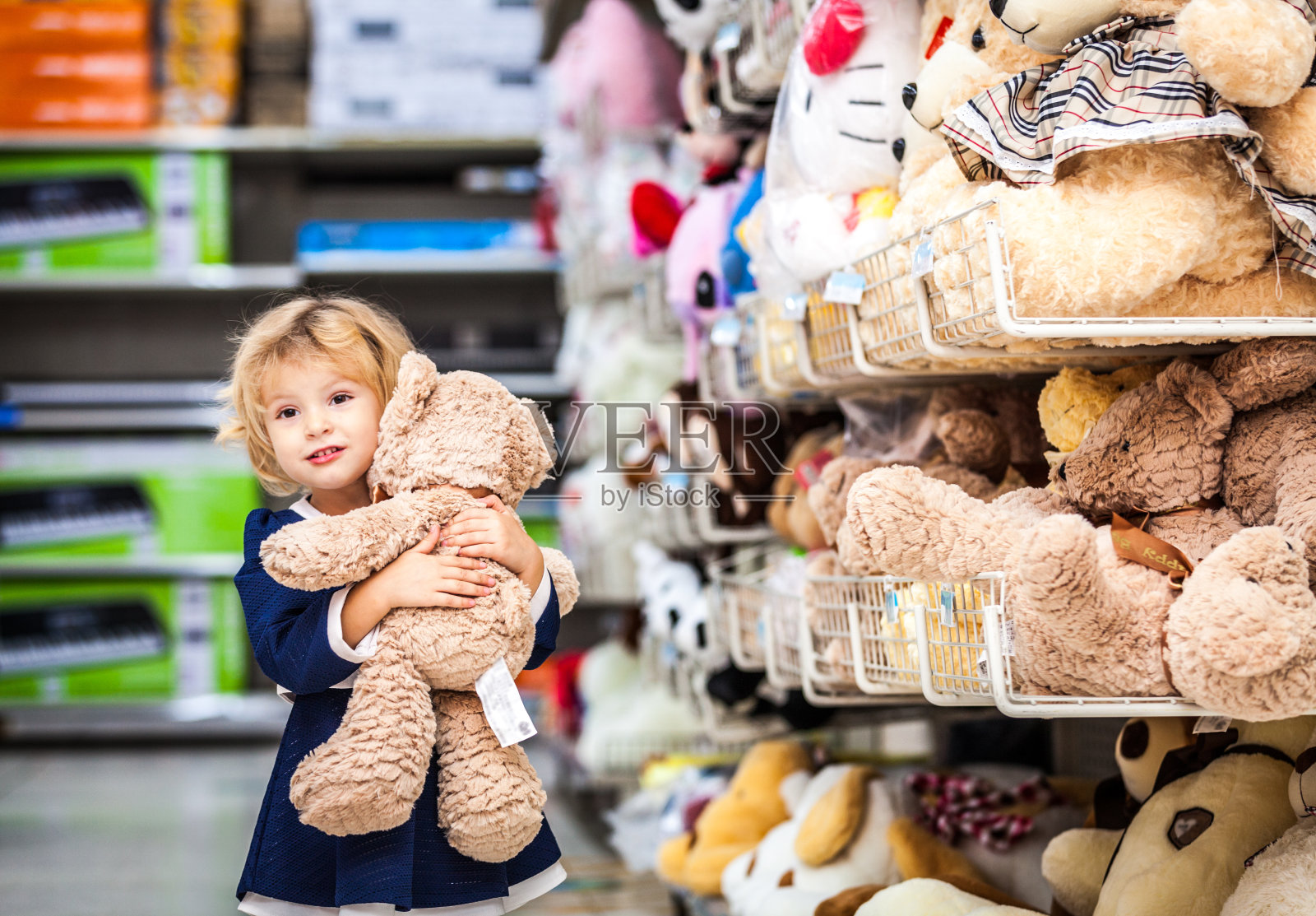 可爱的微笑小女孩和泰迪熊在杂货店照片摄影图片