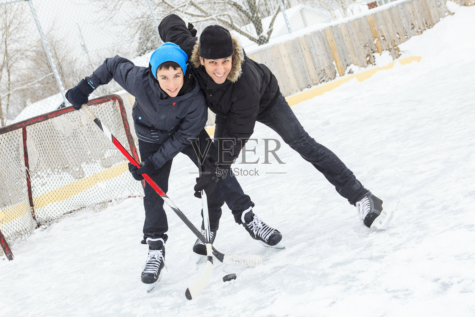 冬天一家人在溜冰场玩。照片摄影图片