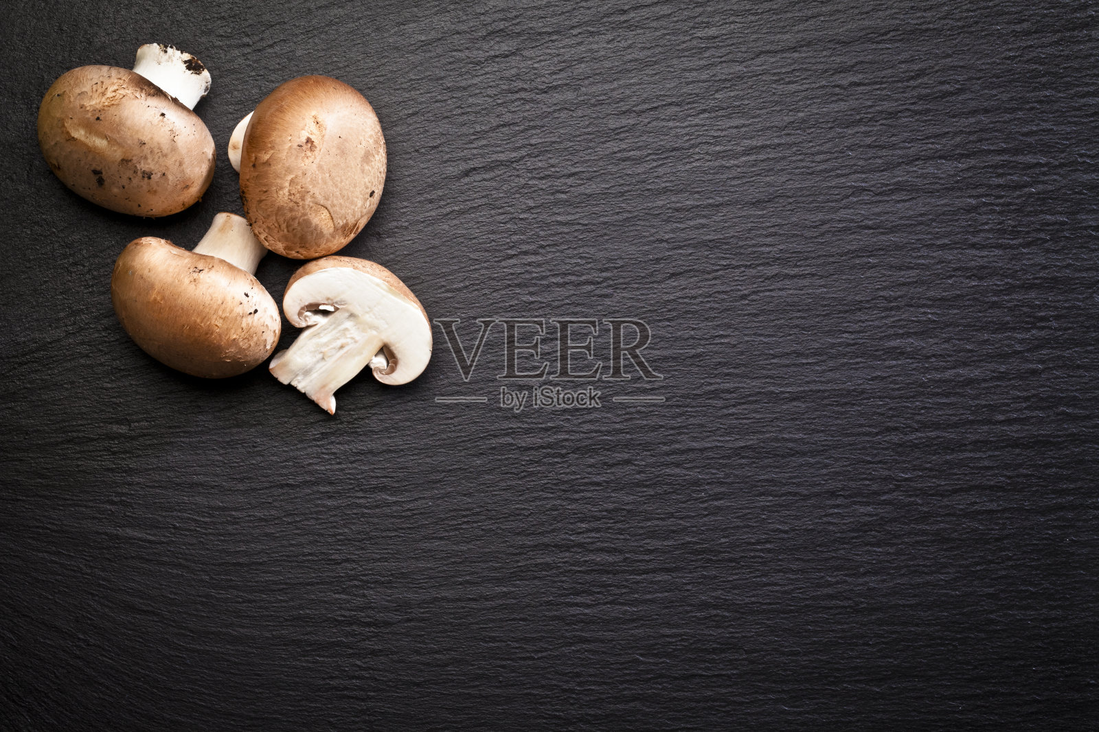 波多贝罗蘑菇在黑色石板背景直接拍摄上方照片摄影图片