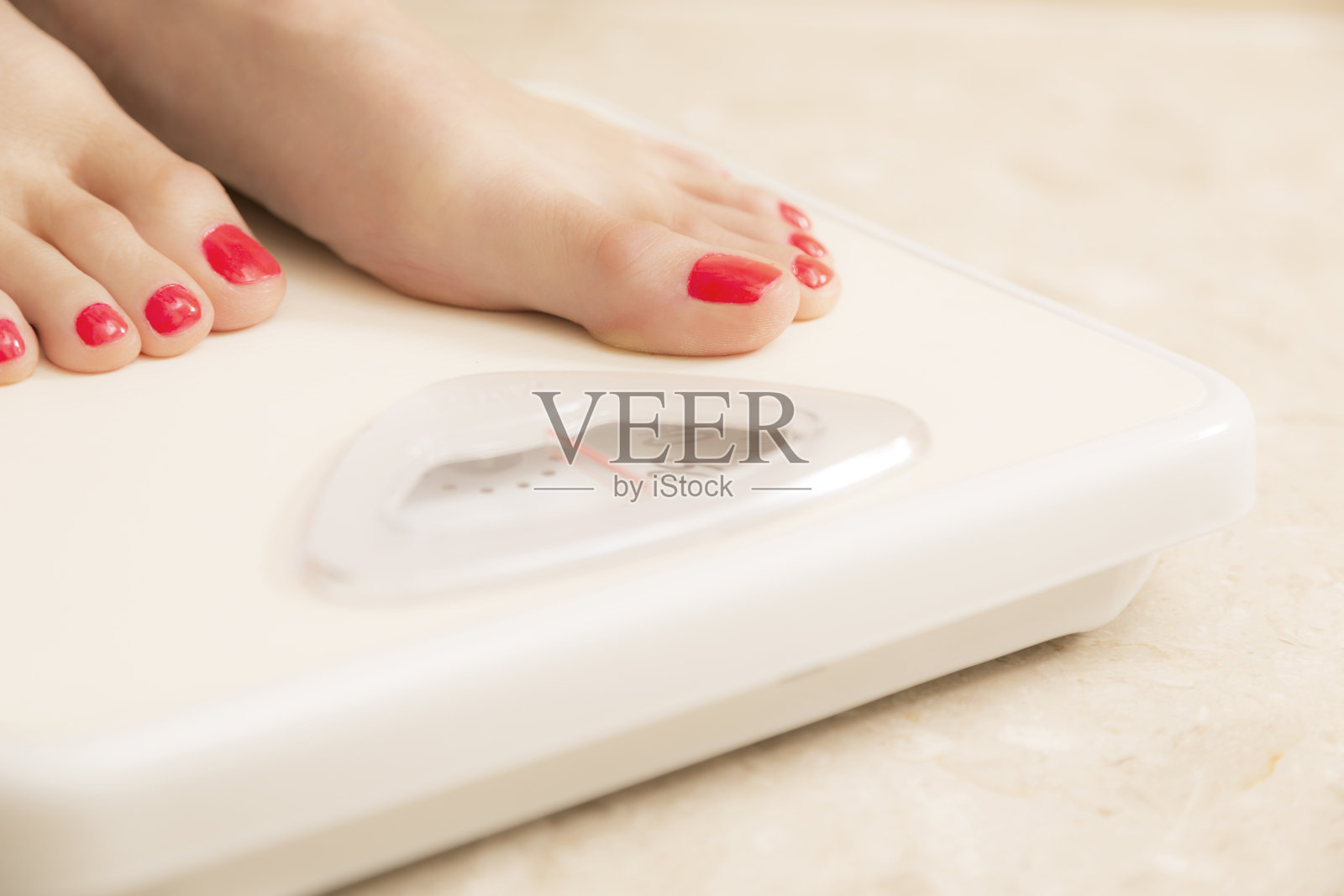 健康生活方式:节食妇女踩在浴室秤上。照片摄影图片