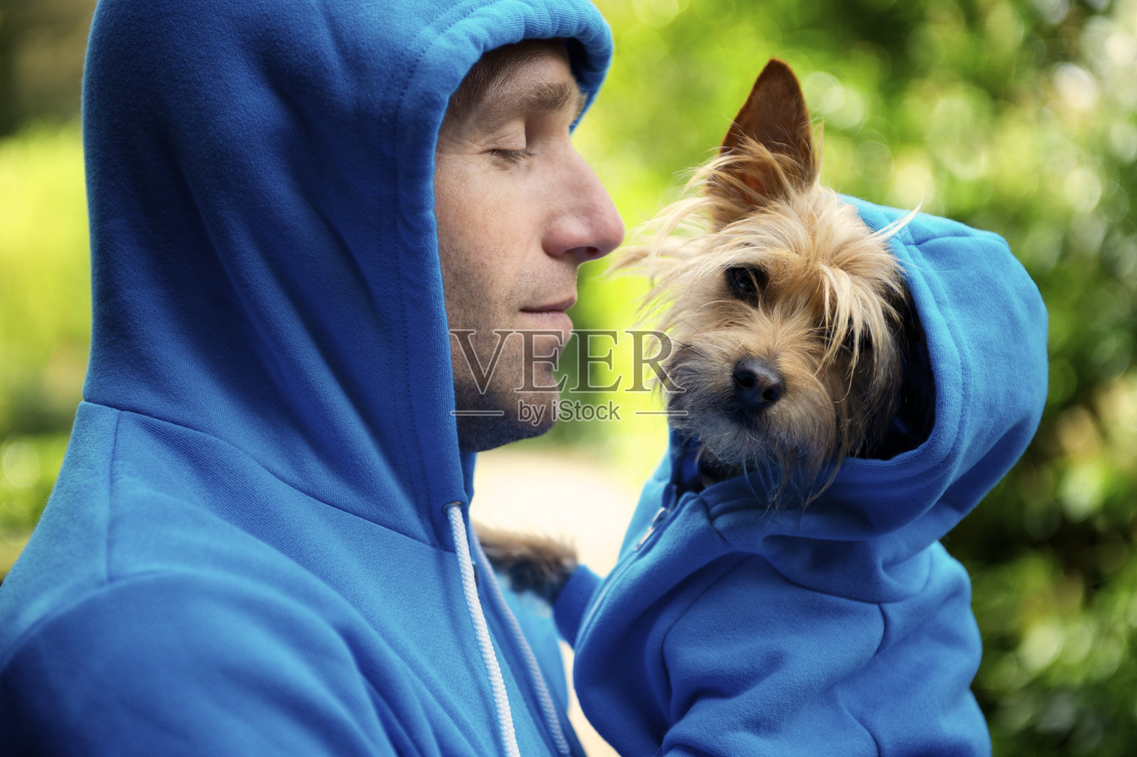 年轻人最好的朋友狗搭配蓝色帽衫户外公园照片摄影图片