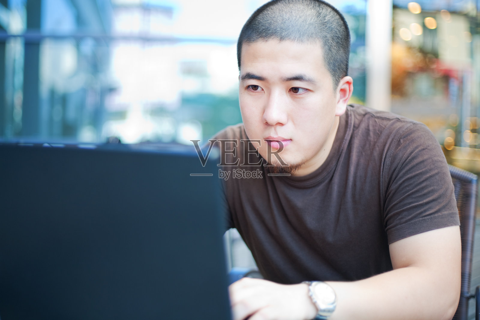 一个年轻人在咖啡馆里专注地看着他的笔记本电脑照片摄影图片