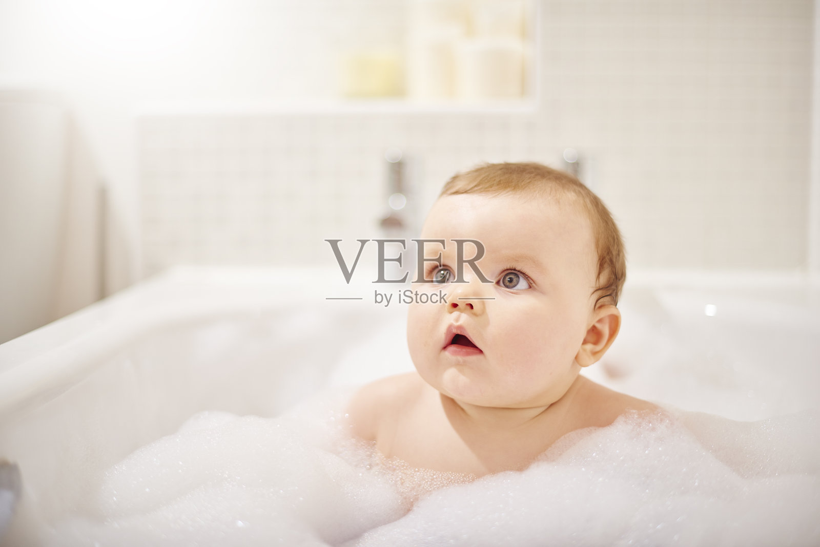 男婴坐在浴缸里照片摄影图片