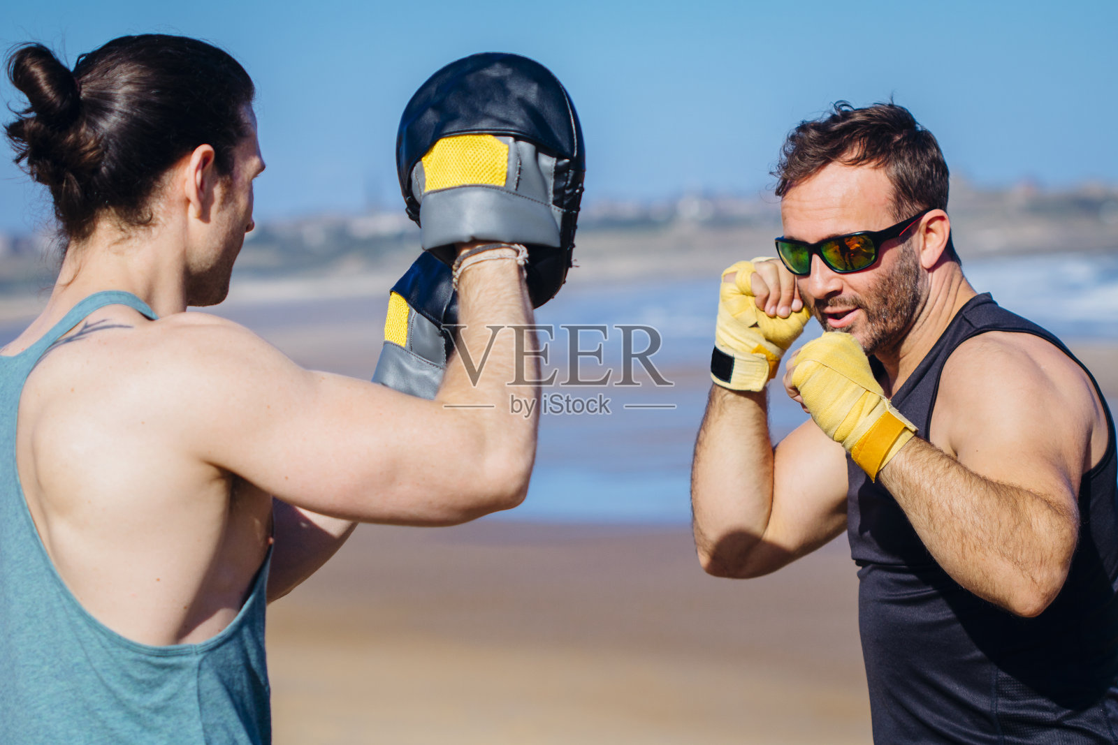 在海滩上一起训练的男人照片摄影图片