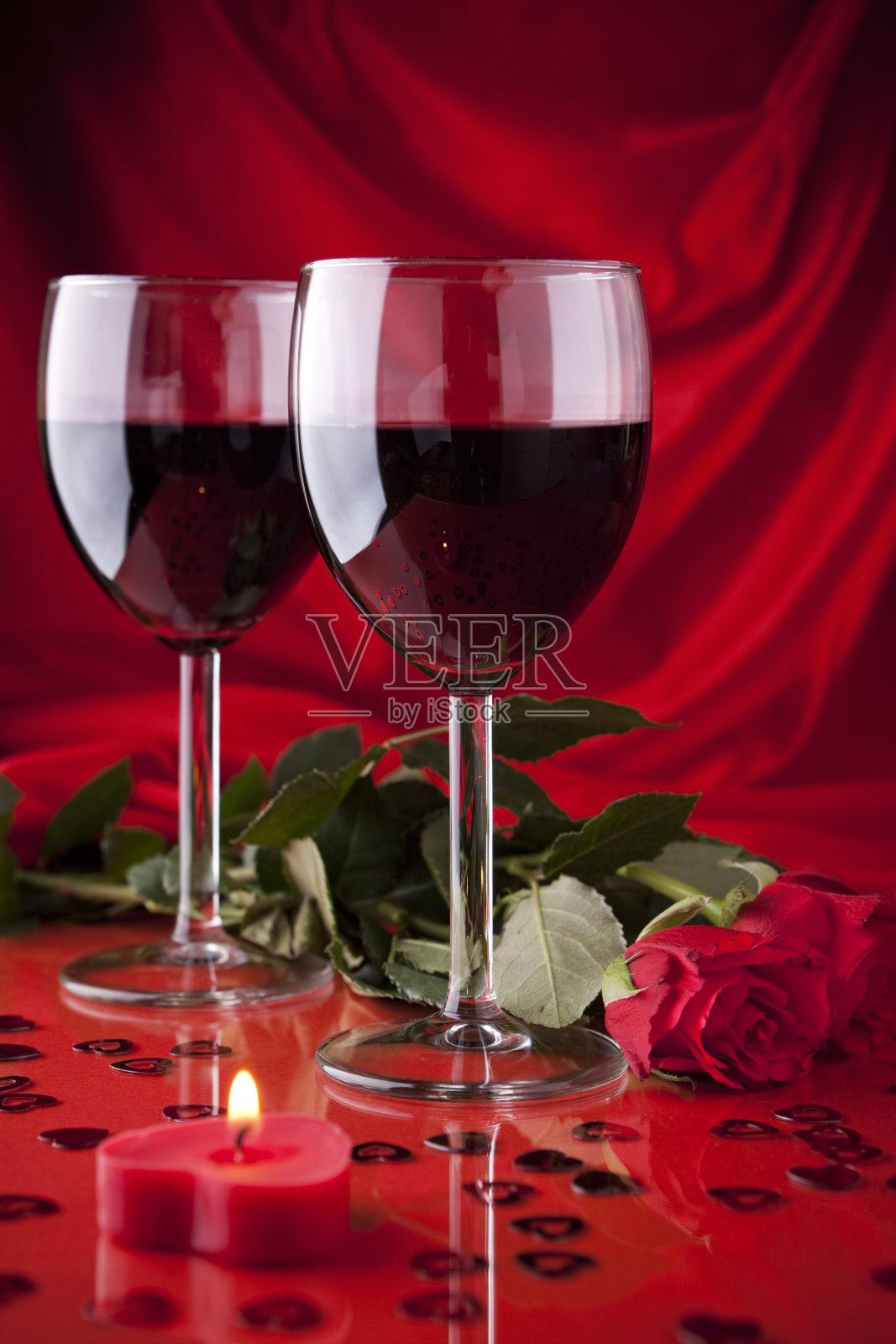 一杯红酒，一支蜡烛和一支玫瑰照片摄影图片