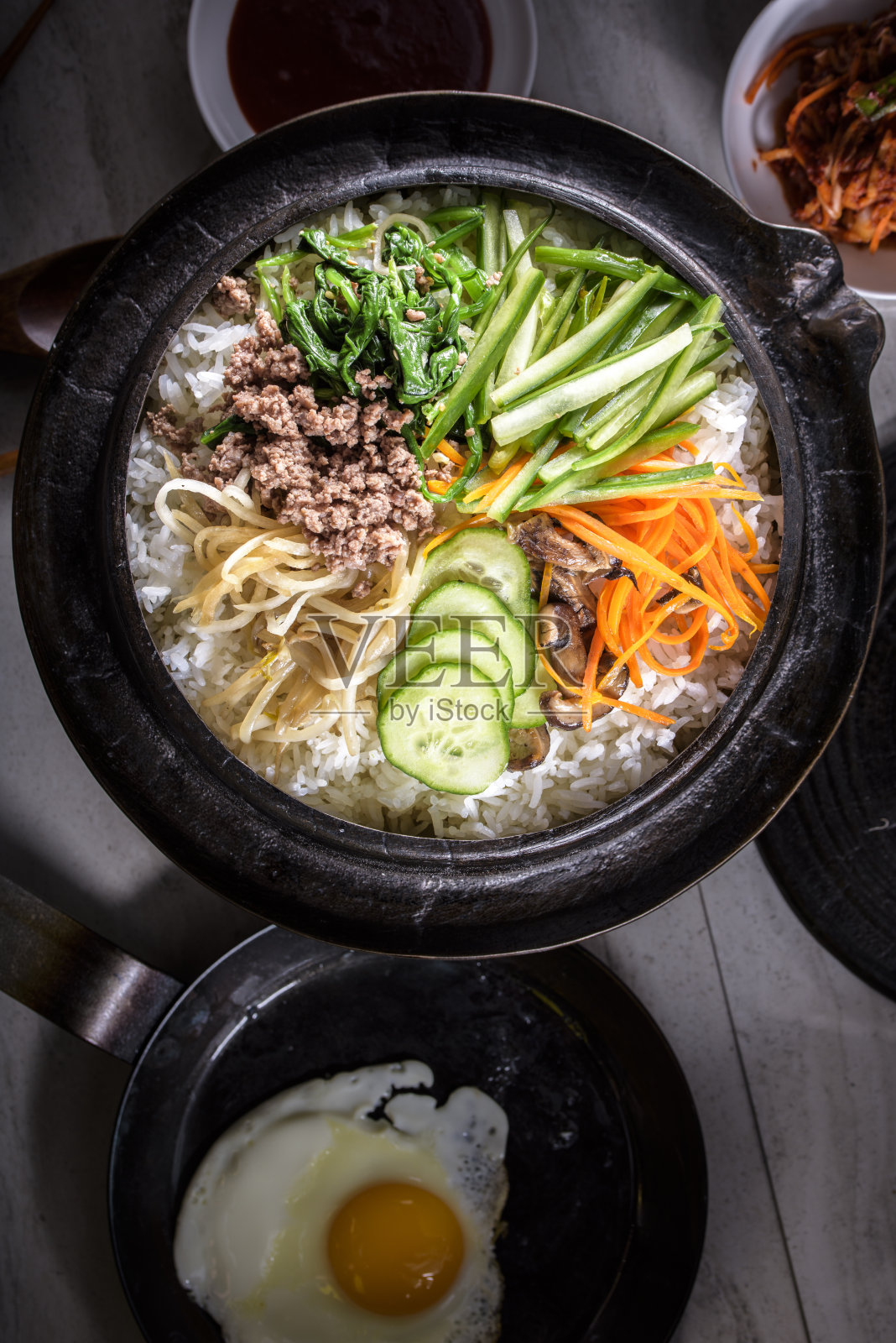 韩式石锅拌饭，拌菜饭，顶视图与热酱在铸铁锅照片摄影图片