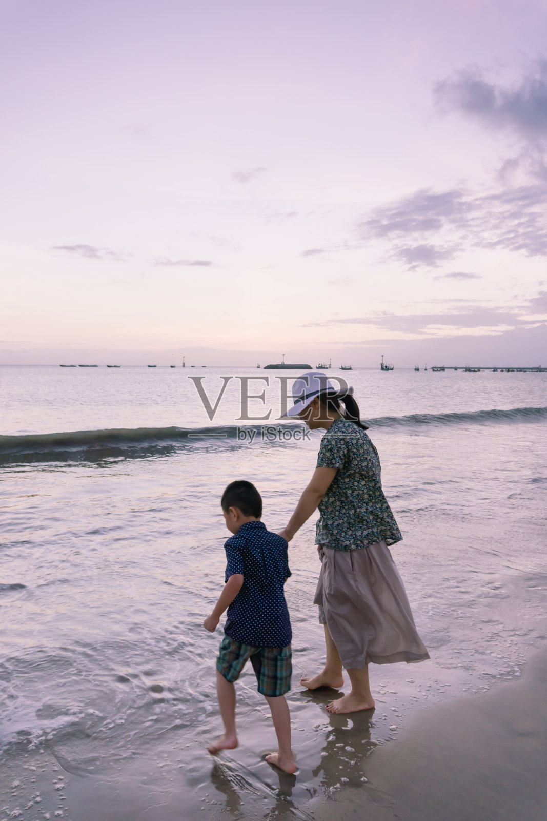 妈妈和儿子在海滩上玩照片摄影图片