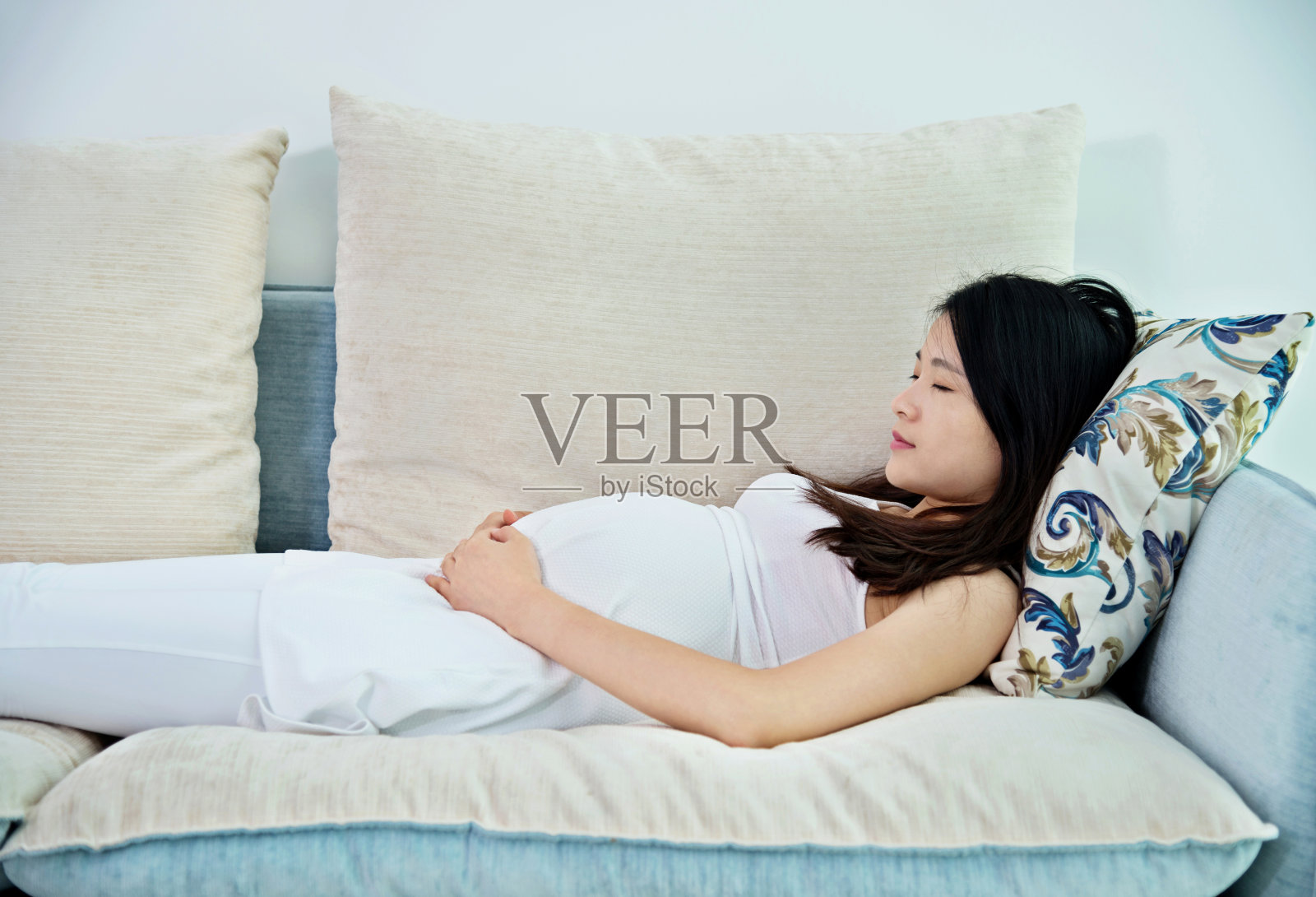 一个孕妇躺在沙发上照片摄影图片