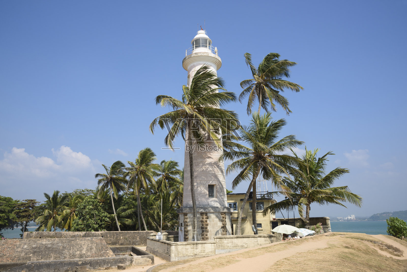斯里兰卡阳光明媚的加勒灯塔和棕榈树照片摄影图片