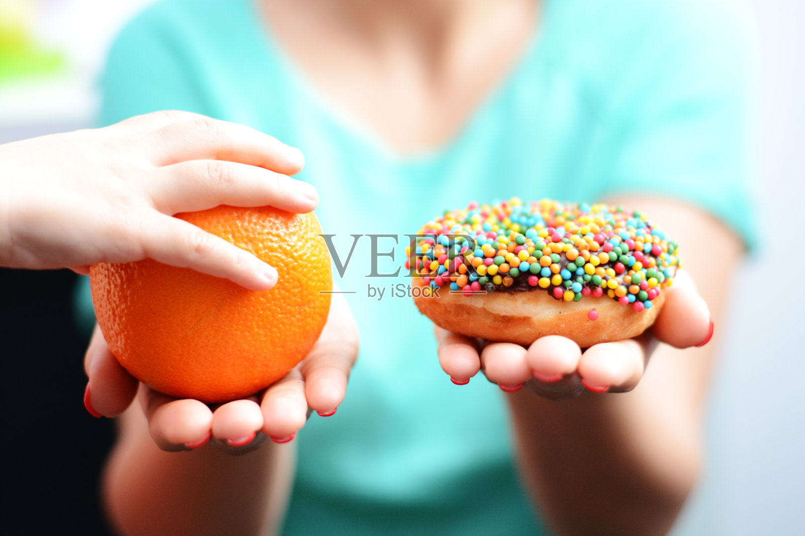 用小女孩选择吃水果，而不是甜甜圈来教育孩子选择健康食品的观念照片摄影图片