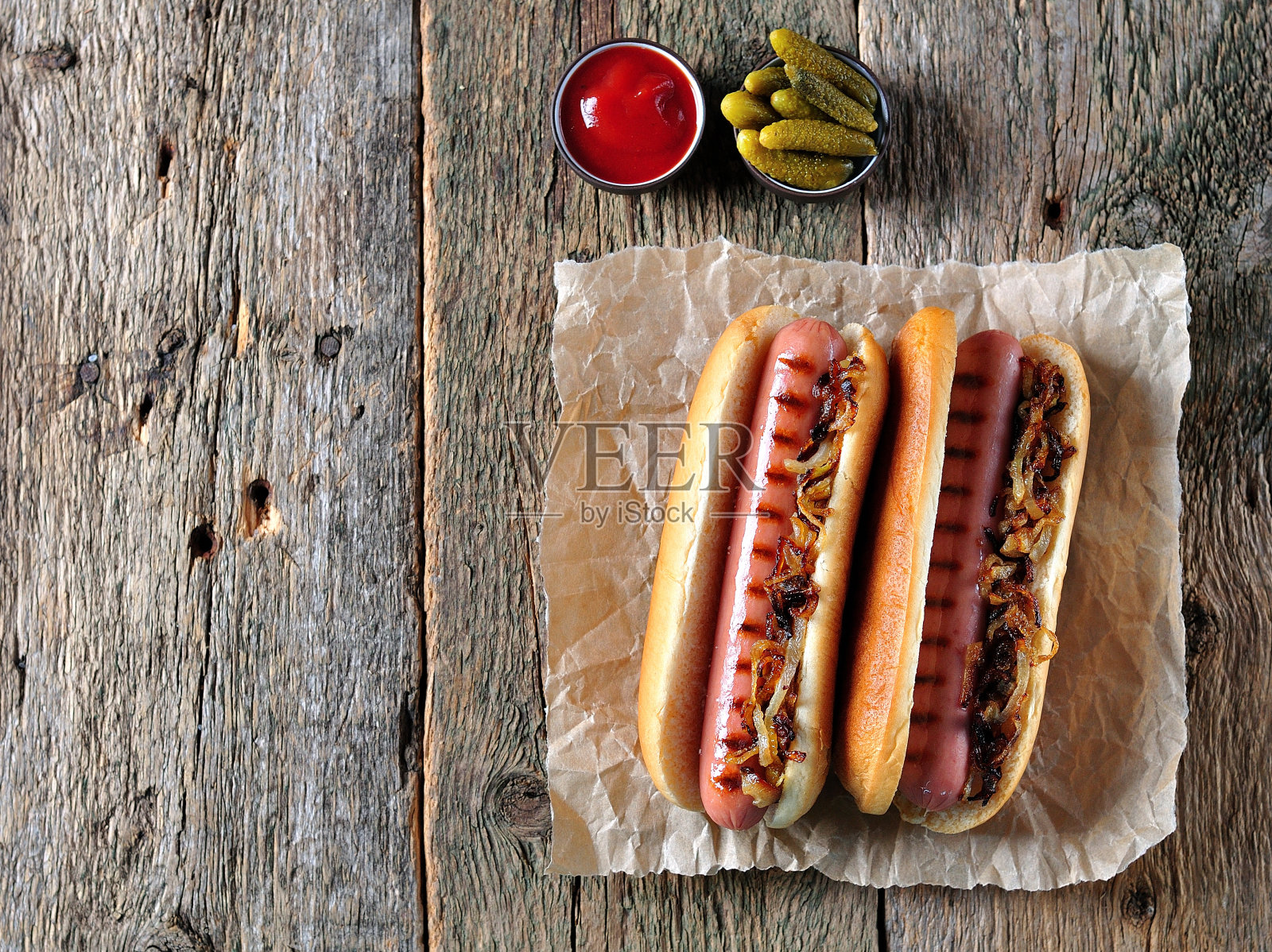两个热狗加脆洋葱和番茄酱。照片摄影图片