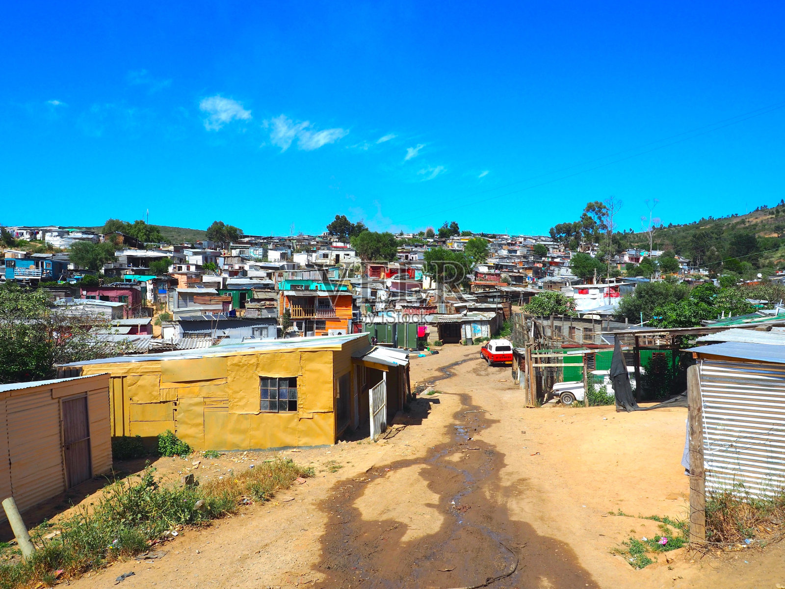 在南非开普敦的Stellenbosch镇，街道上有五颜六色的非正式定居点，由金属制成的棚屋，有蓝天和白云的背景。照片摄影图片